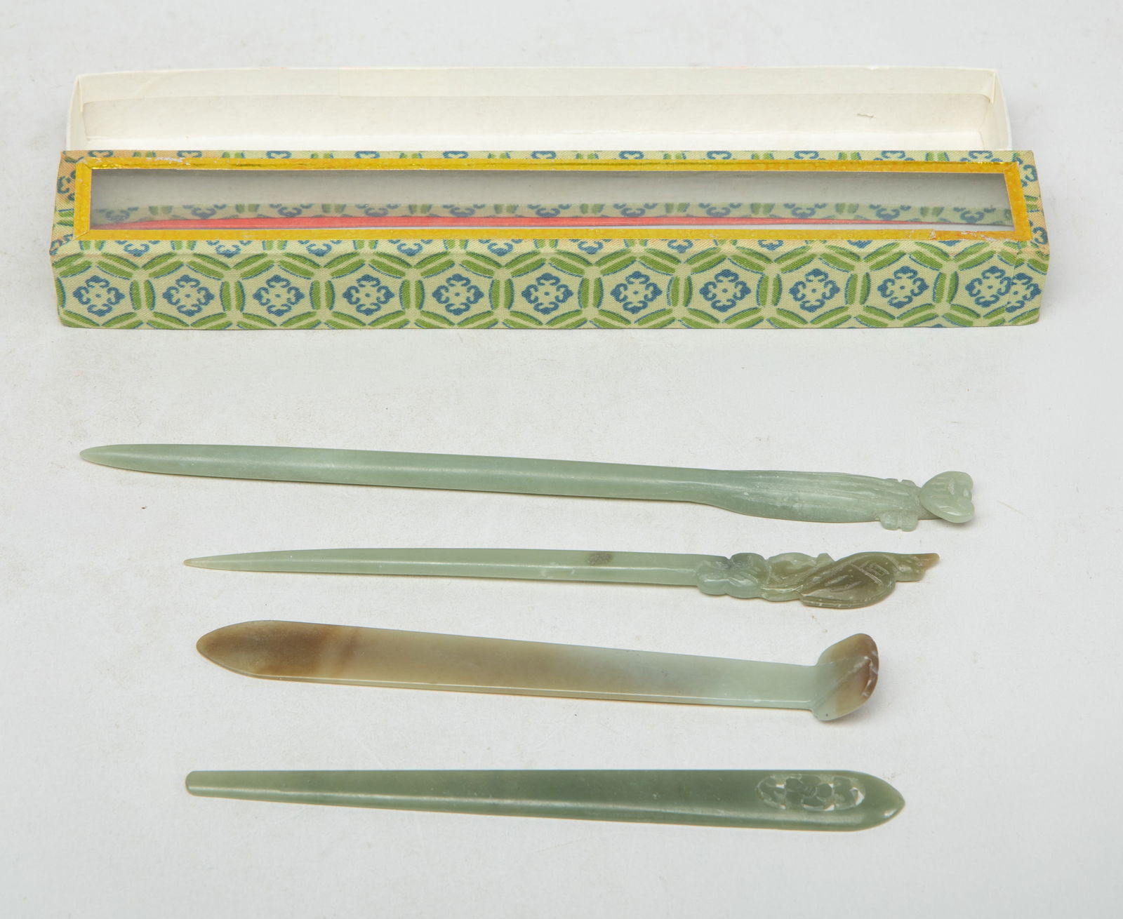 Set Chinese Jade Carved Hairpins: Set of four Chinese celadon and russet jade hairpins, one carved with ruyi, one carved flower, one carved bird, the other incised with shou character, with box. Approx. 7.5 inch (longest hairpin).