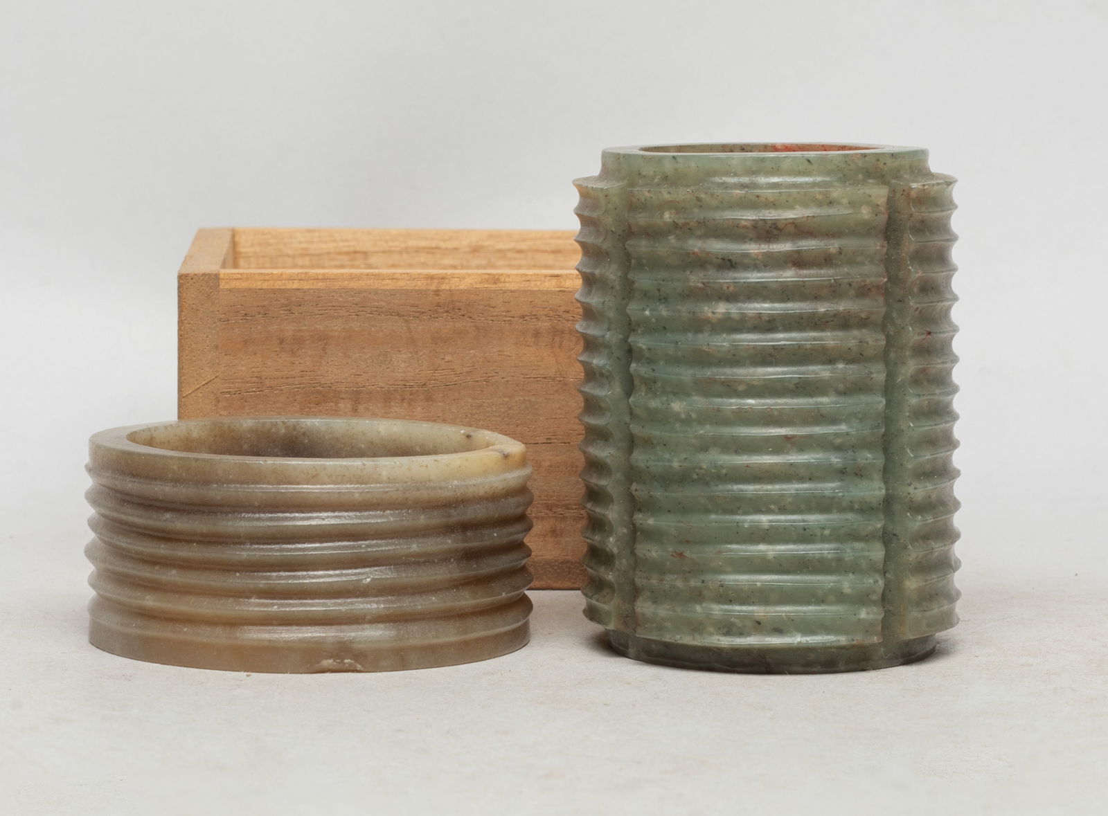 Two Chinese Jade Carved Cong: Two Chinese russet jade cong, of cylindrical form, carved with parallel raised borders around the exterior, with a lidless box. Approx. 2.8*2.1 inch (larger). The Estate of the Store Closed Sale, Litt
