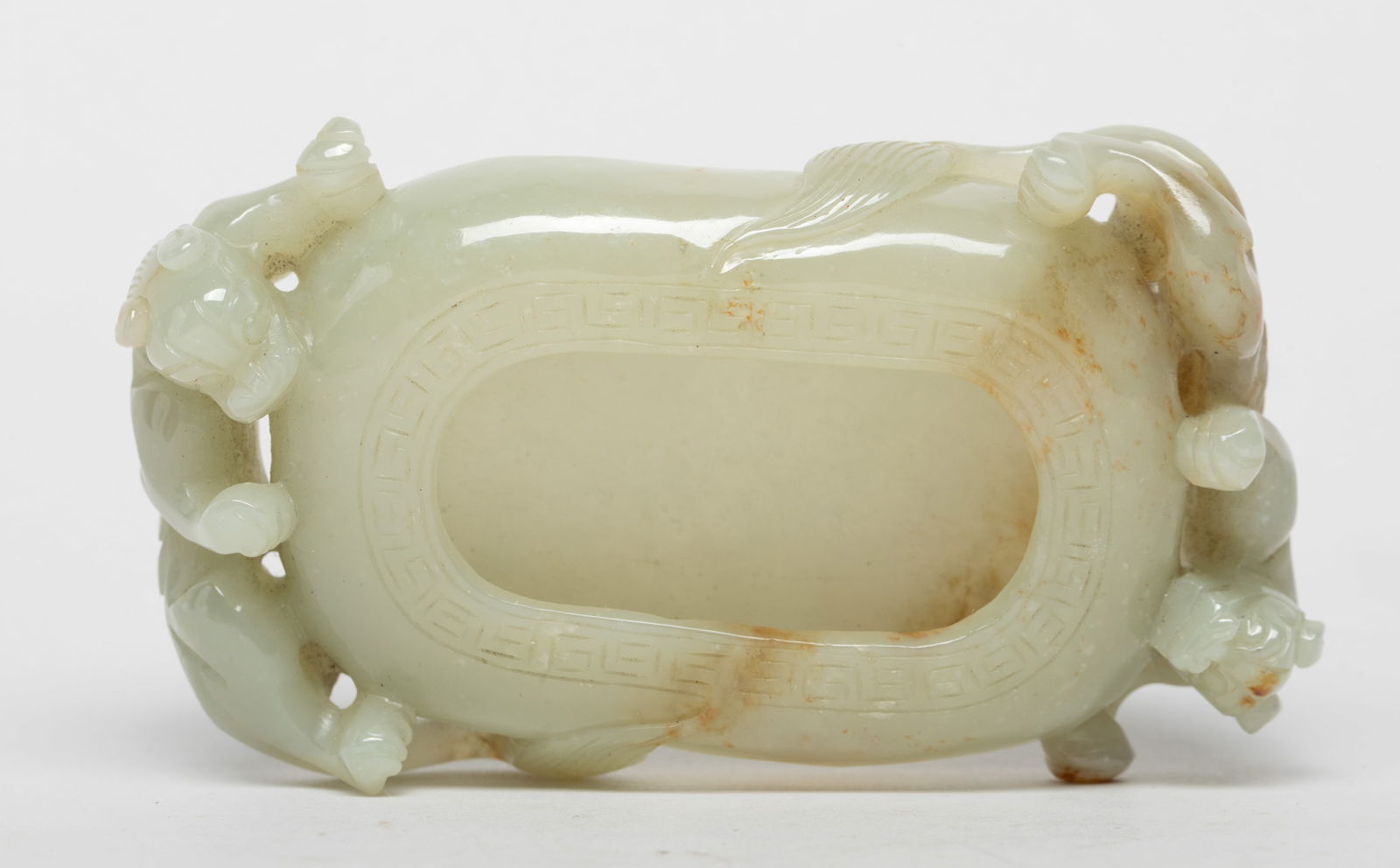 Rare Chinese Export Jade Brush Washer: The shallow ovoid washer flanked by two writhing chilong clambering up each side, the stone of a pale celadon tone with a russet inclusion. Approx. 4.2*2.5*0.9 inch.