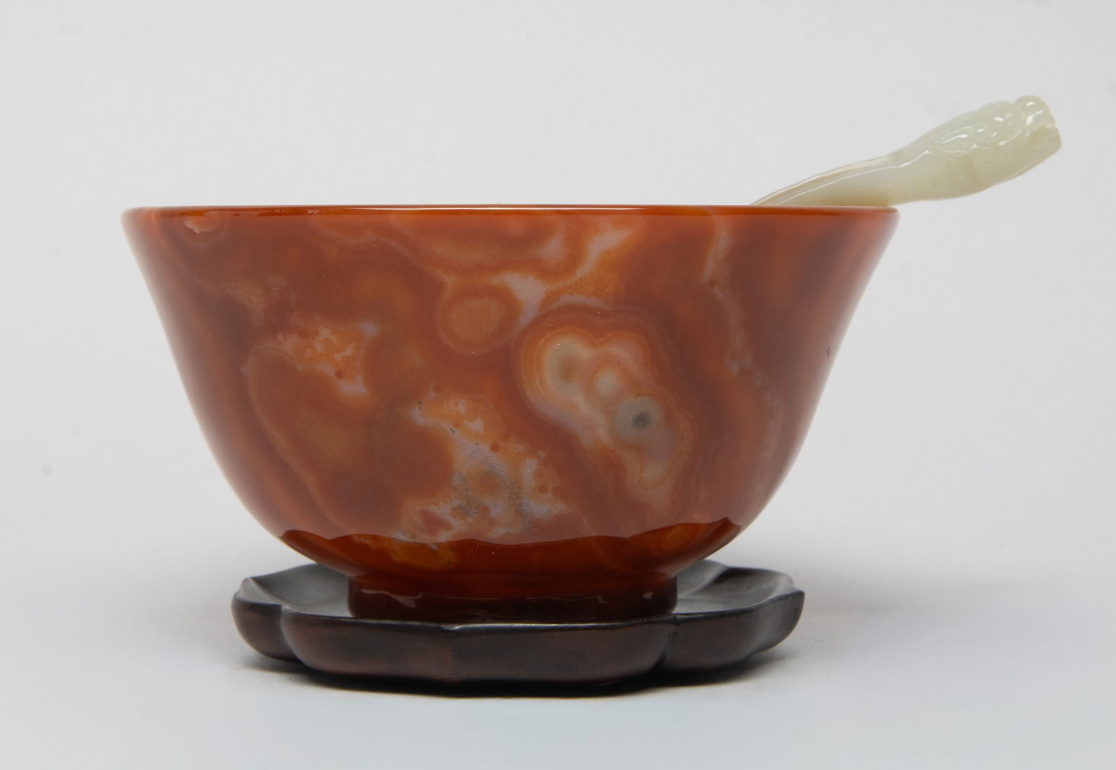 Chinese Cameo Agate Bowl, Jade Spoon: Chinese red cameo agate carved bowl, the surface is finely smoothed and polished, with a russet jade spoon, and a wood base. Approx. 4.6*2.4 inch (bowl size).