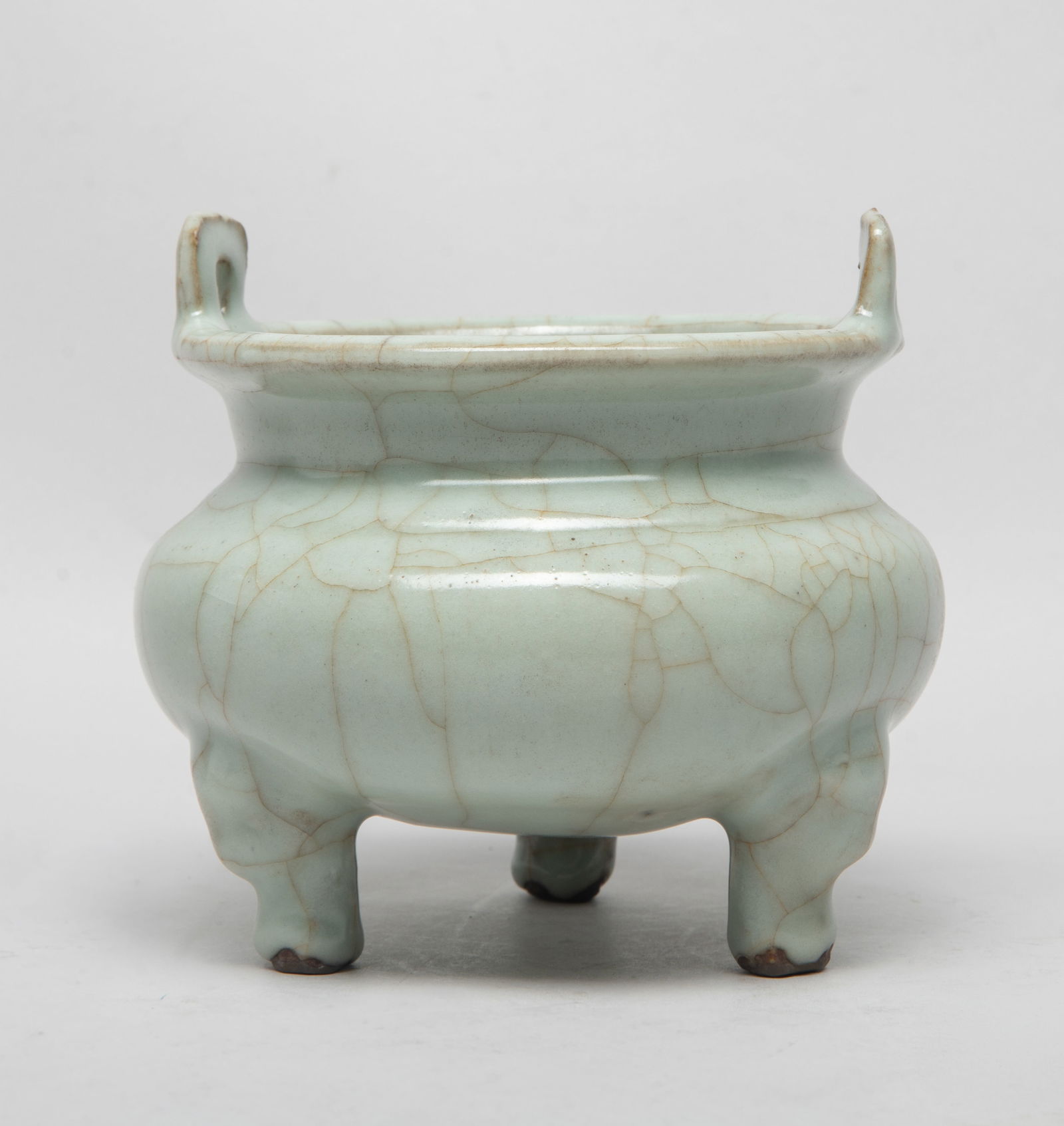 Rare Chinese Export Porcelain Censer: The compressed body rising to a short neck and a flared rim with two upright handles, all supported on three cabriole legs, overall covered in soft celadon glaze suffused with a network of brown crack