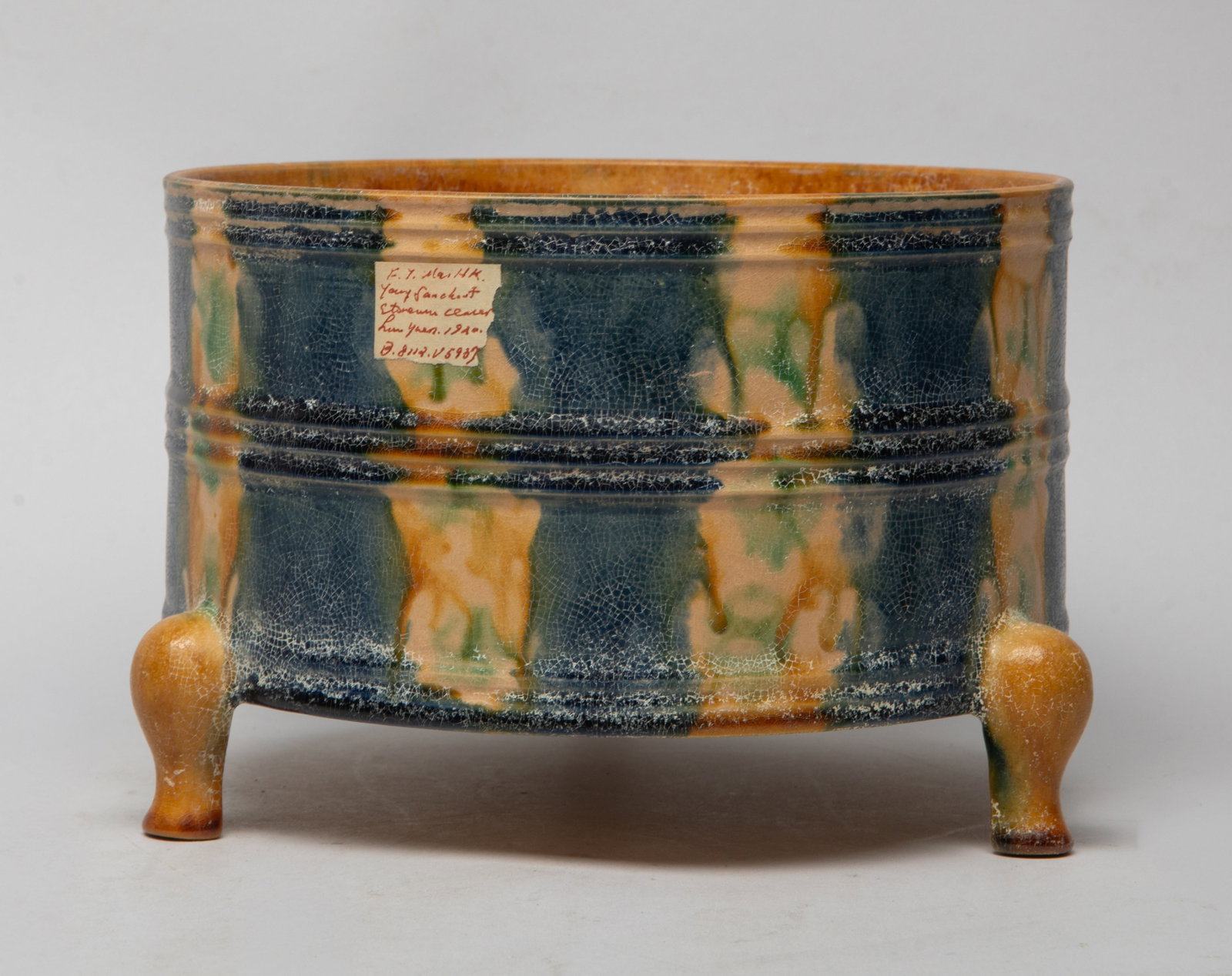 Rare Chinese Sanchai Porcelain Censer: Of cylindrical form with three short cabriole legs, the interior applied with crackled honey-brown glaze, the exterior carved with raised borders, applied with blue, beige, green and brown glaze, the 