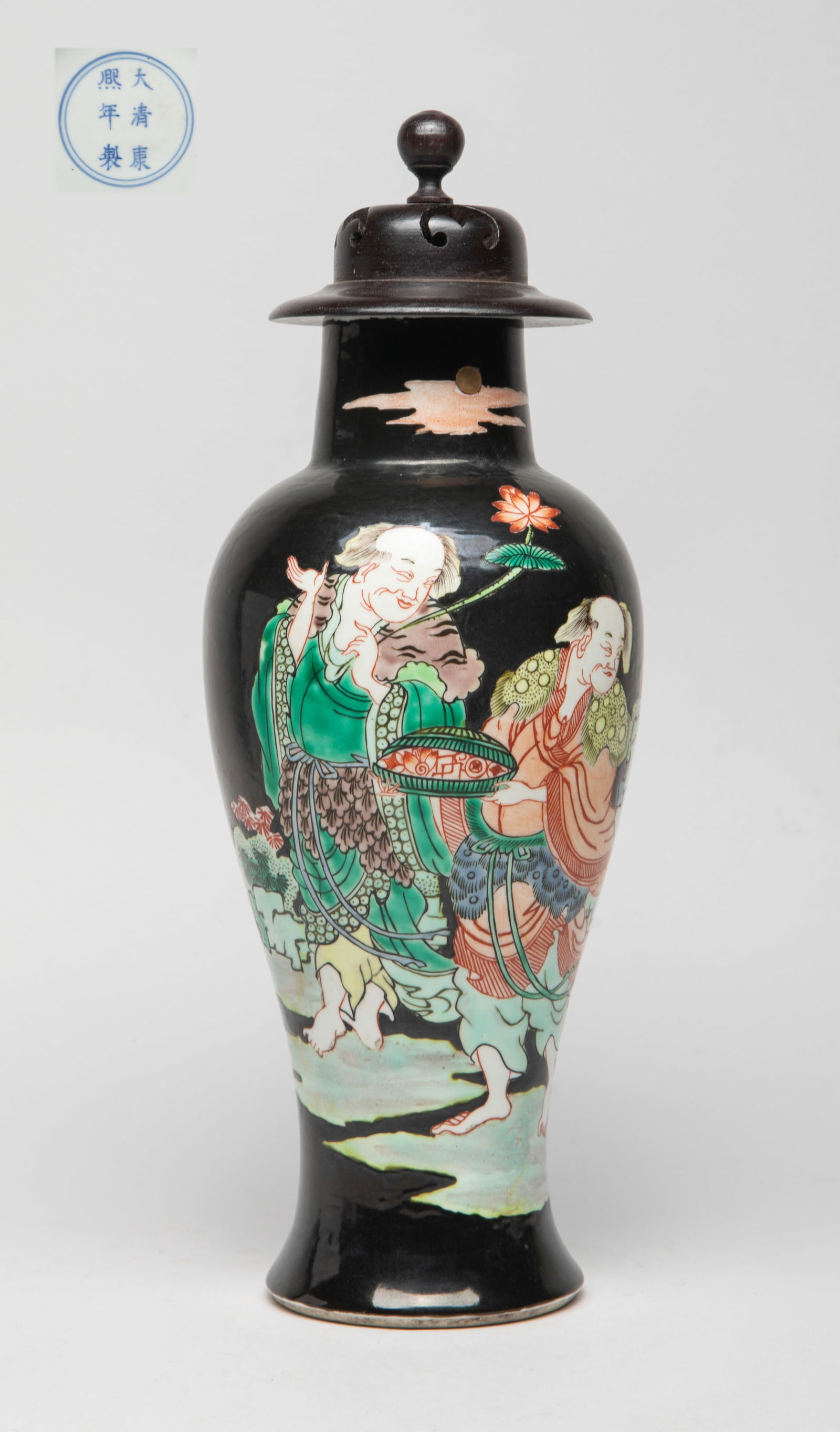 Estate Chinese Wuchai Porcelain Vase w/ Cover: Of baluster form rising from a splayed foot to a columnar neck, the body painted with Hehe Erxian, one figure holding a box and the other holding lotus, against black glazed background, the bottom mar