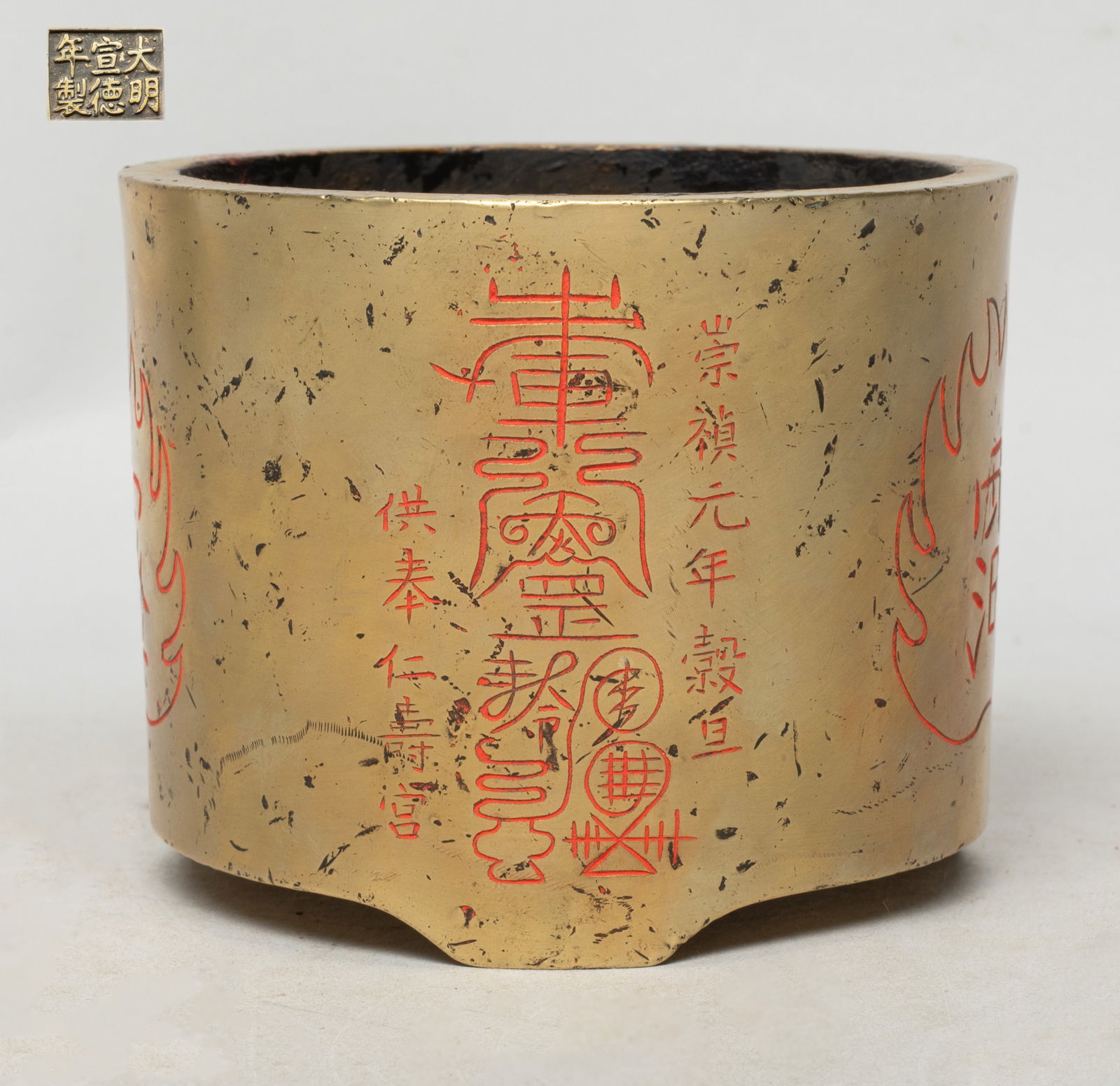 Rare Chinese Bronze Cabinet Censer: Of cylindrical form, the exterior carved with three flame shaped medallions enclosing stylized characters, inscribed with mysterious characters, the bottom carved with a six-character mark. Approx. 4.