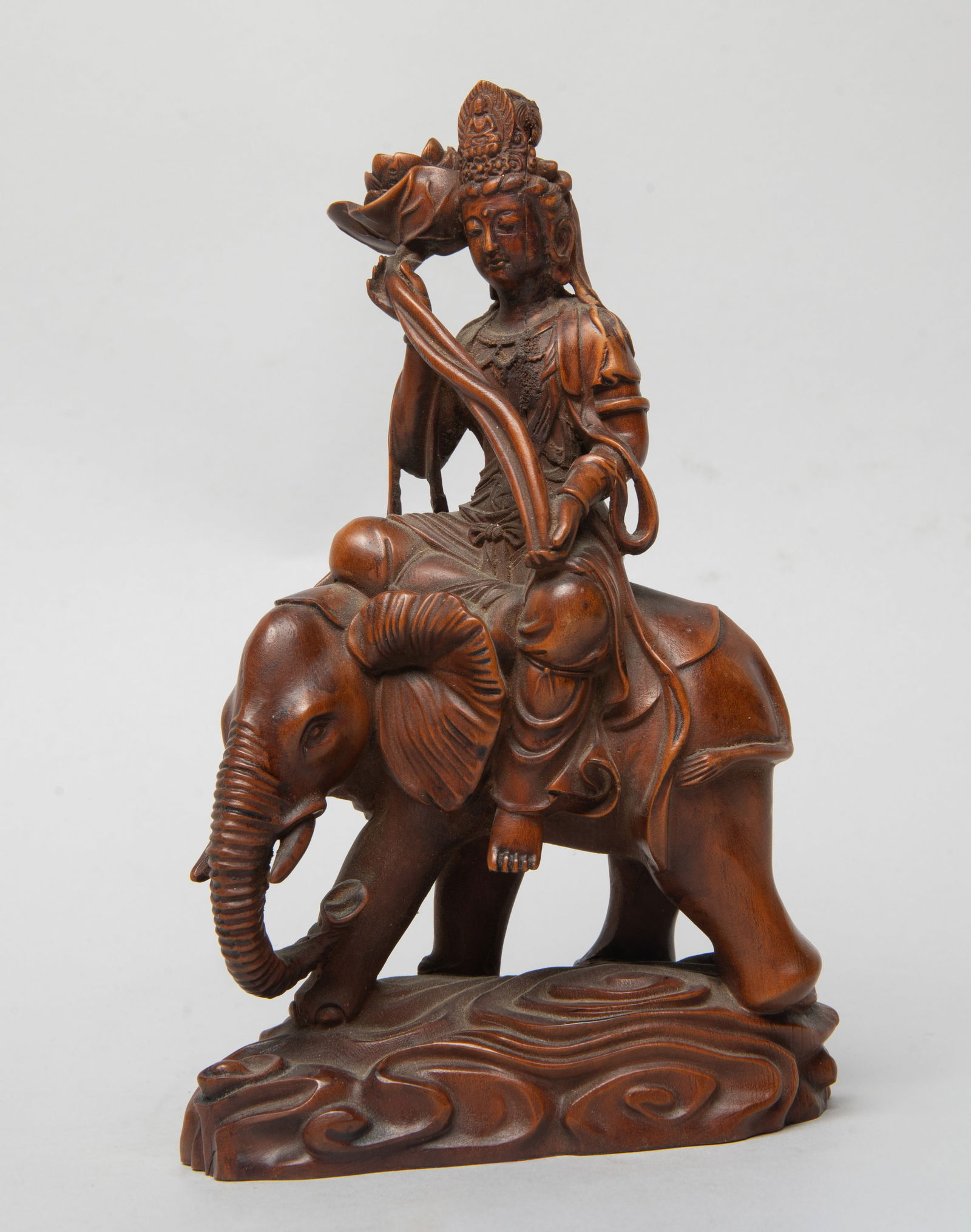 Estate Chinese Wood Sculpture of Buddha: Carved as Buddha seated on a standing elephant above scrolling clouds, the hands holding lotus, the face with serene expression. Approx. 6.6*4.1*1.7 inch.