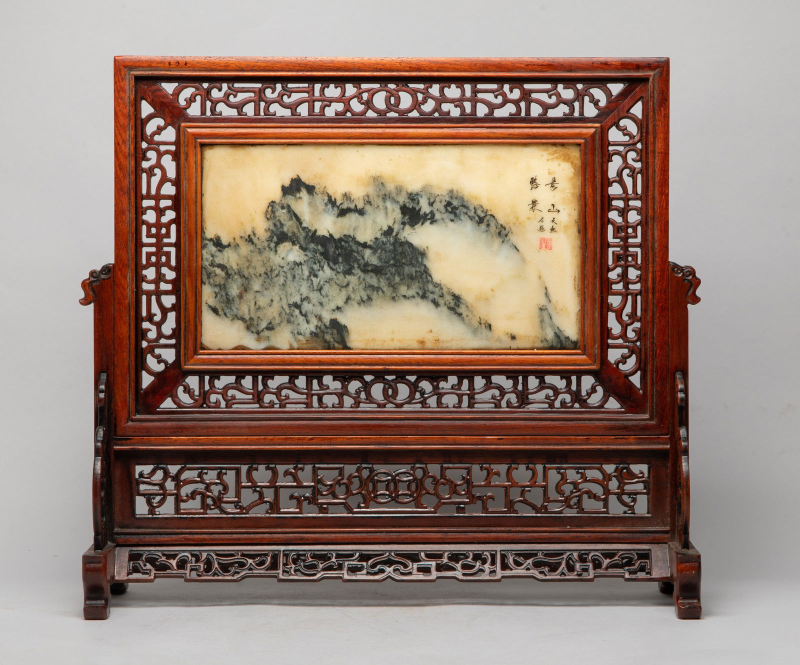 Estate Chinese Export Wood, Marble Table Screen: The rectangular marble panel variegated with black and beige striations forming a mountain landscape, inscribed with related passages, carved wood frame raised on a stand with further fretwork detaili