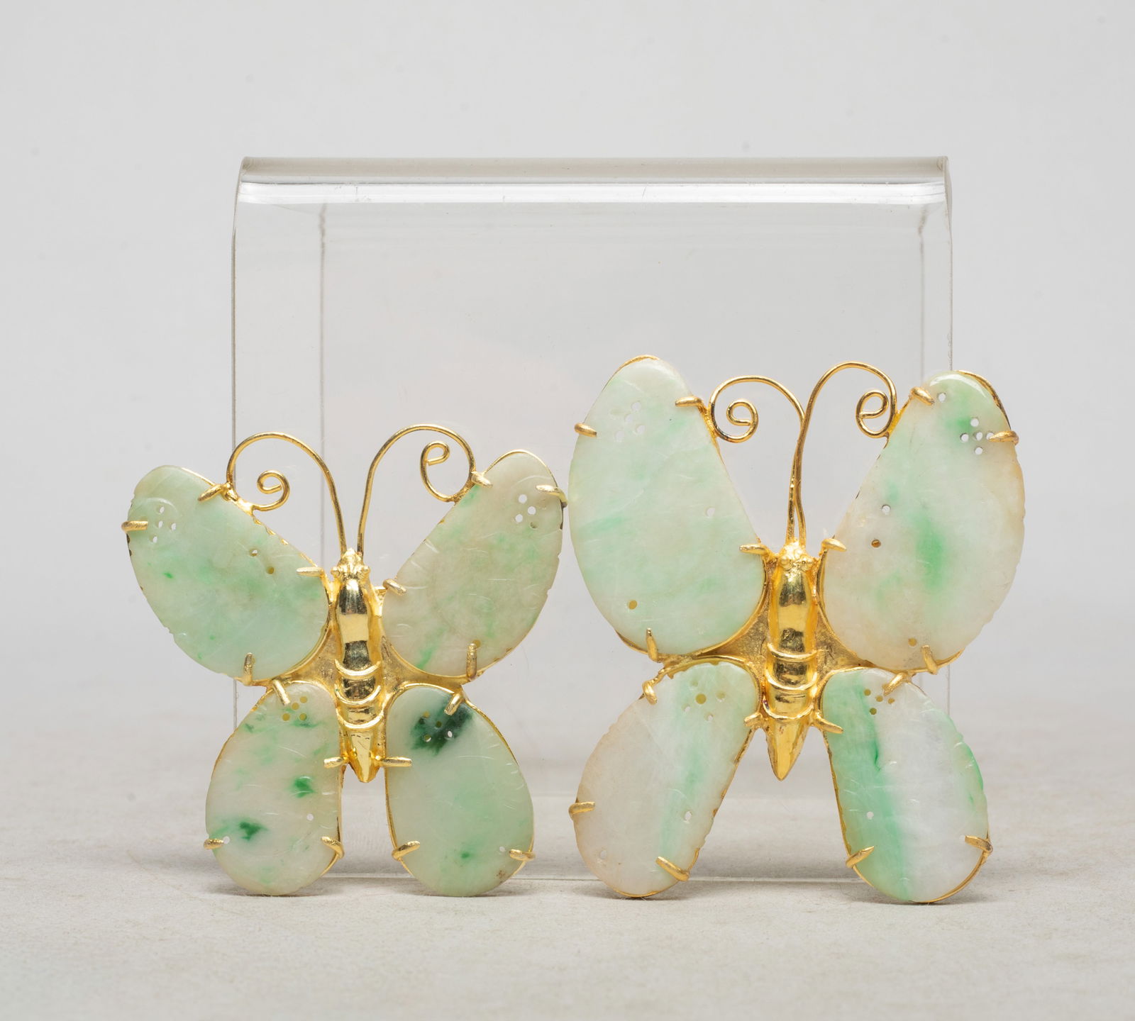 Two Chinese Jade, Gold on Silver Brooches: Two Chinese gold-on-silver brooches of butterfly form, inlaid with jade. Approx. 2.2*1.9 inch (larger). The Estate of the Moving & Heritage Sale, E Los Angeles. 2023.