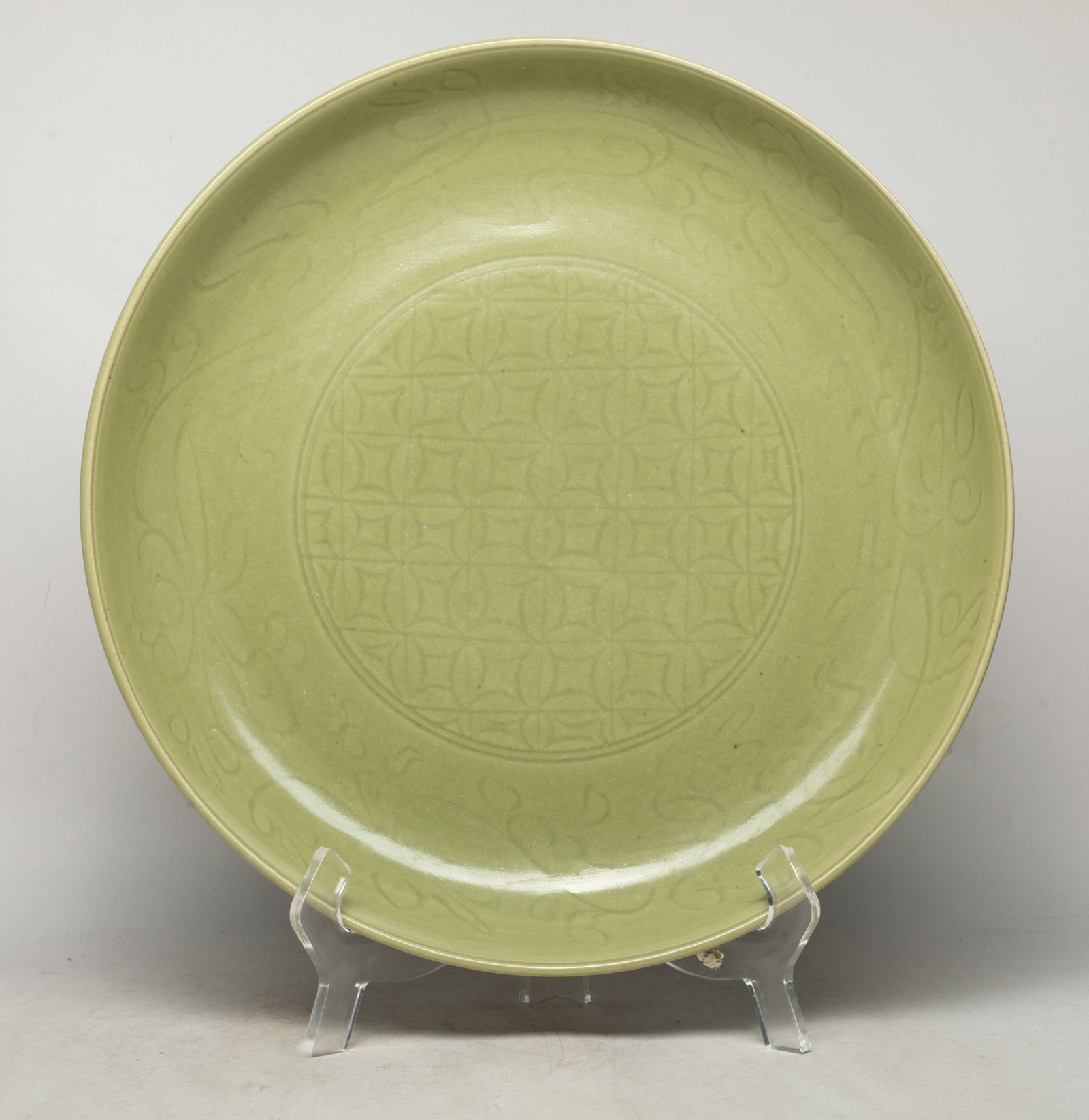 Chinese Export Longquan Porcelain Charger: The charger interior centre incised with a circular panel of coins motif, the sides with stylized floral patterns, overall covered with olive-green glaze. Approx. 15.7*2.3 inch.