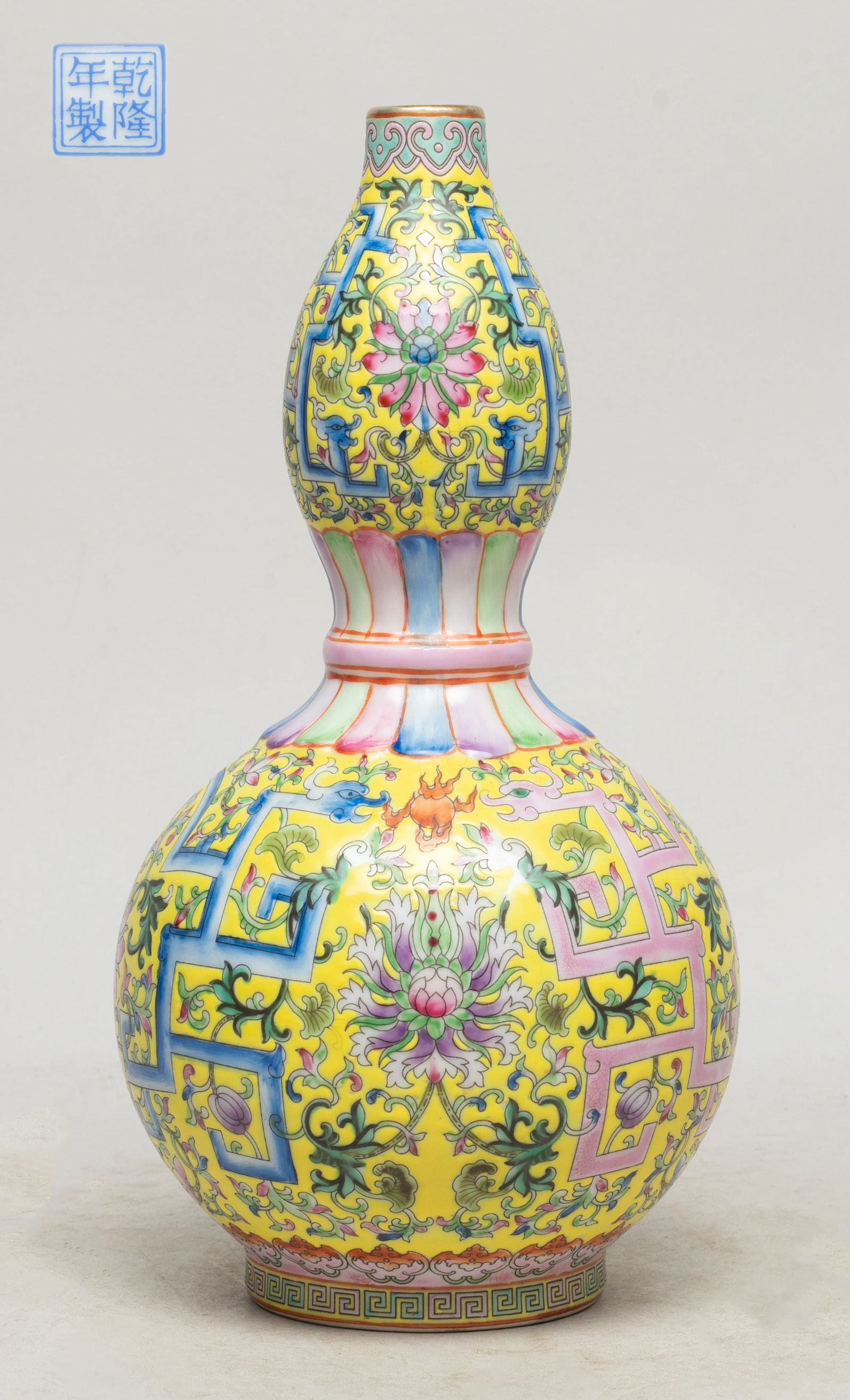 Chinese Famille Rose Porcelain Gourd Vase: Of double gourd form, the exterior enameled and painted with stylized dragons among dense lotus scrolls, against bright-yellow glazed background, the bottom with a seal mark. Approx. 9.6*4.8 inch.