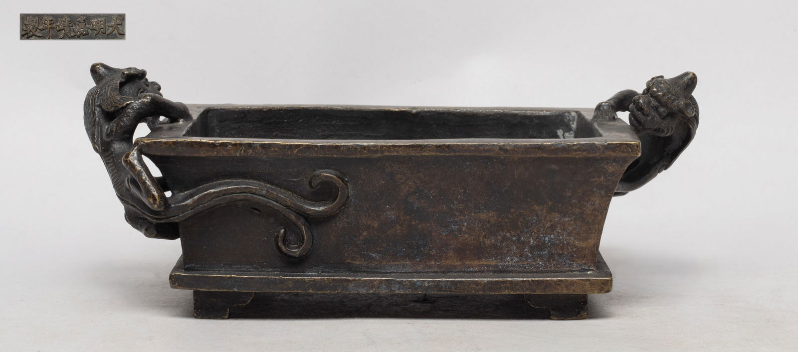 Rare Chinese Bronze Cabinet Censer: Of flared rectangular section, flanked by a pair of beasts clambering along the narrow sides, the bottom marked with six characters. Approx. 7.2*4.1*2.7 inch. The Estate of the Moving & Heritage Sale,
