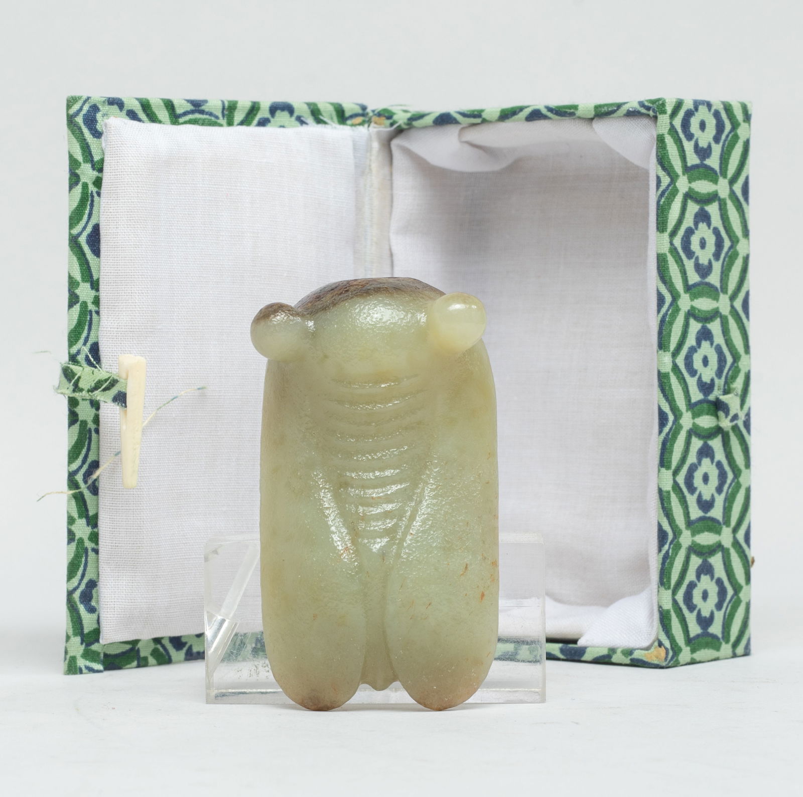 Chinese Russet Jade Pendant of Cicada: Chinese russet and pale celadon jade pendant carved of cicada form, drilled through the head for suspension, with box. Approx. 2.55*1.4*0.8 inch (jade size). The Estate of E Los Angeles, CA, 2021.