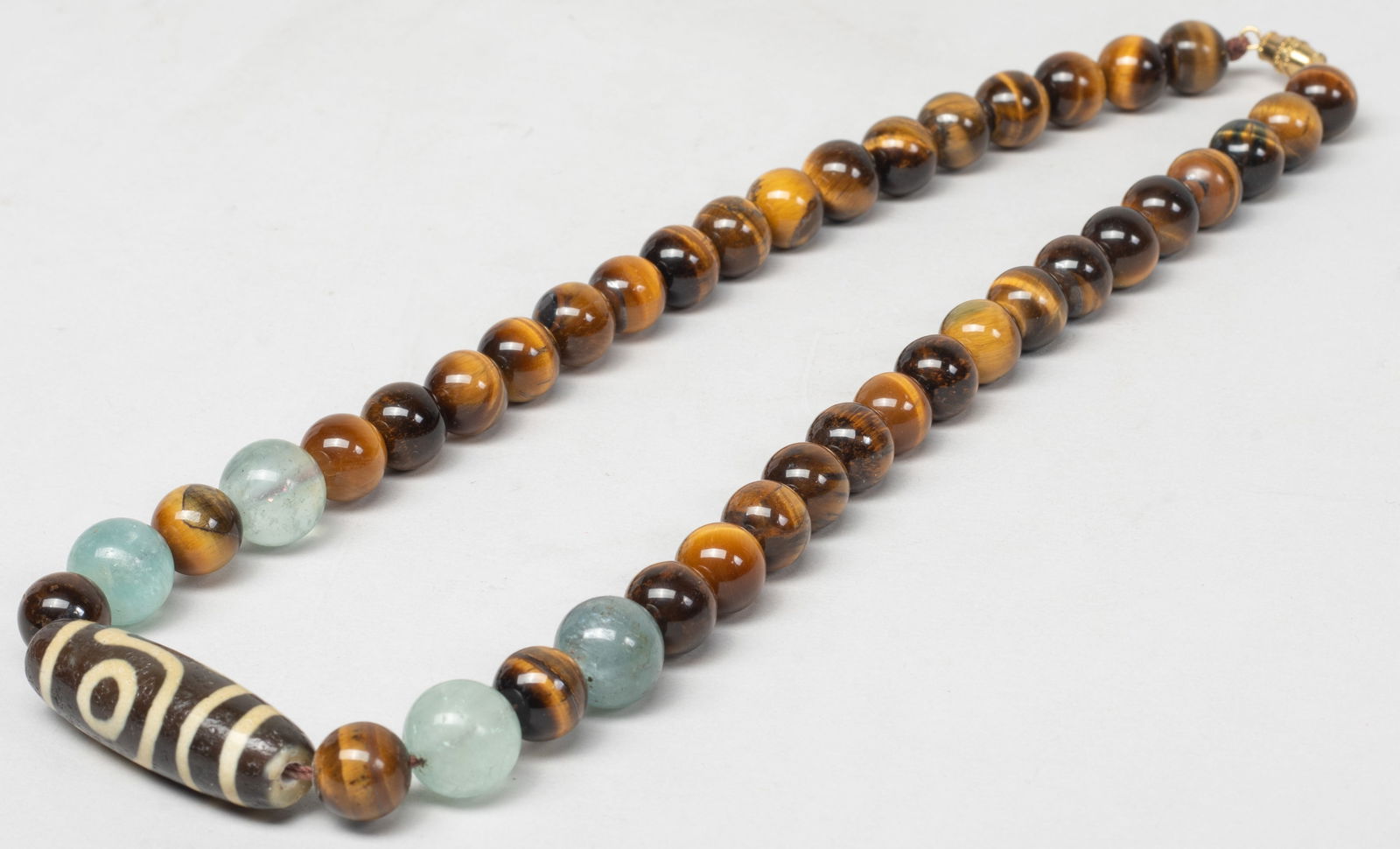 Vintage Chinese Aquamarine, Tiger-eye,Dzi Necklace: Vintage Chinese tiger eye gemstone bead necklace, with four aquamarine beads and a dzi bead. Approx. 18inch L. The Estate of the Store Closed Sale, DTLA, 2020.