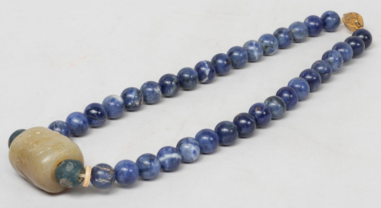 Rare Chinese Export Lapis, Jade Necklace: Chinese lapis bead necklace with two glass beads and a large russet jade bead carved with a chi dragon. Approx. 17 inch L. The Estate of the Store Closed Sale, DTLA, 2020.
