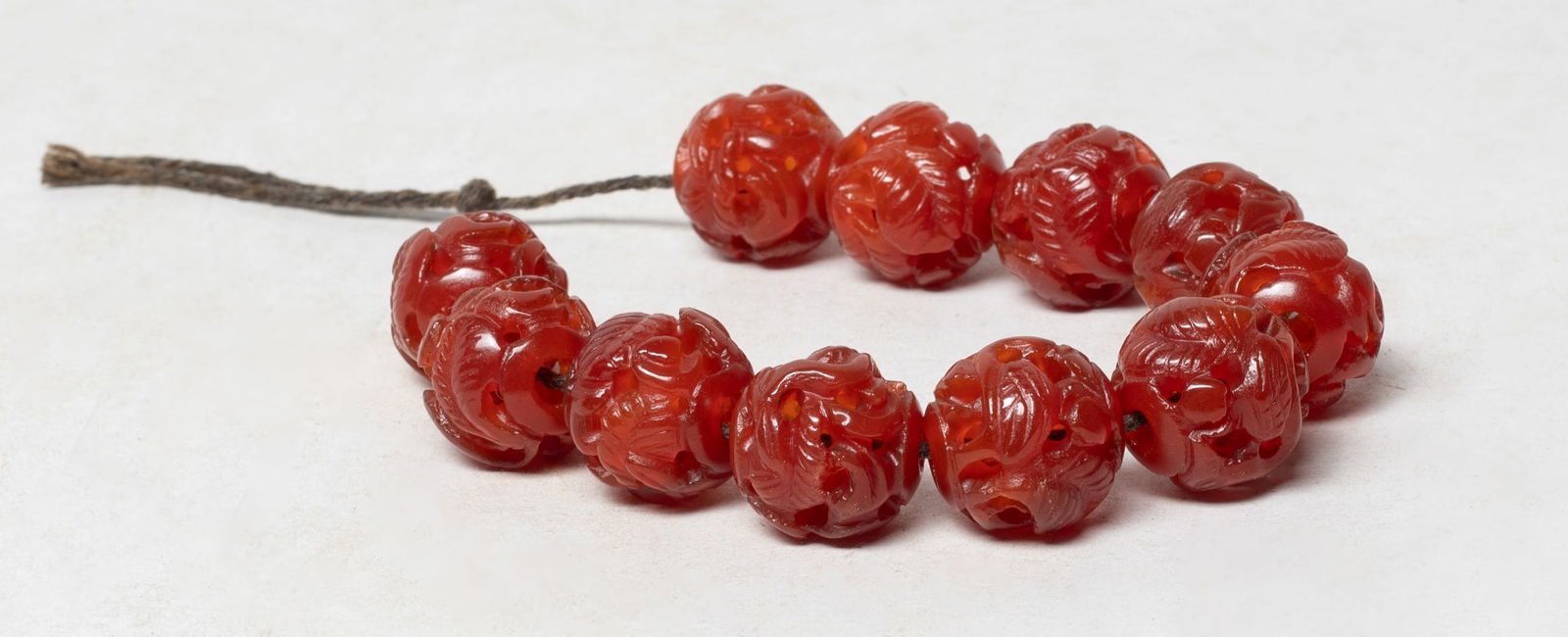 Estate Chinese Agate/Stone Prayer Beads: Set of 11 Chinese agate / stone prayer beads, carved in openwork with bird among leafy stems. Approx. 0.75 inch D (each bead size).