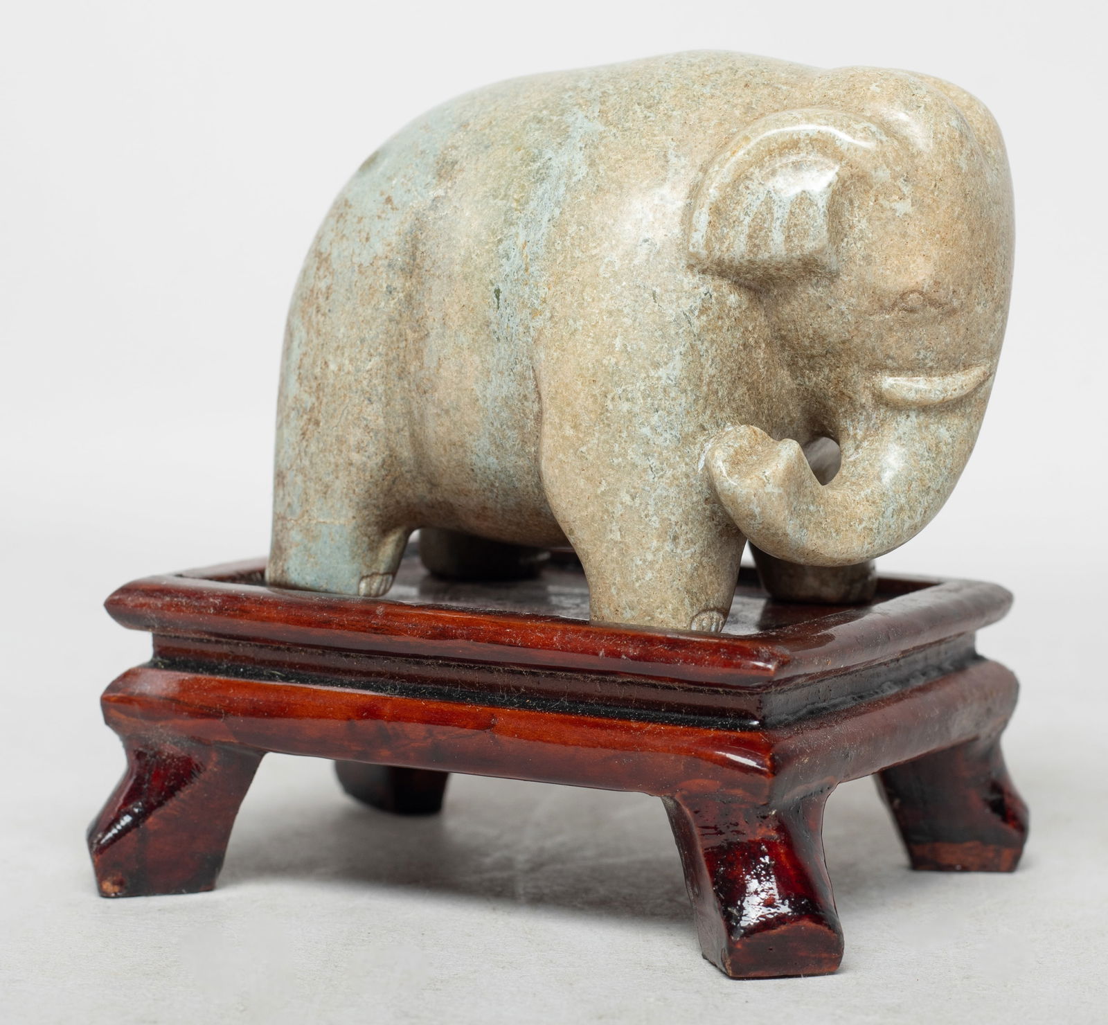Chinese Export Burnt Jade/ Stone Sculpture: Chinese burnt jade / stone sculpture carved in standing elephant form, the nose turning to the right, with stand. Approx. 3*2.3*1.9 inch (w/o stand).