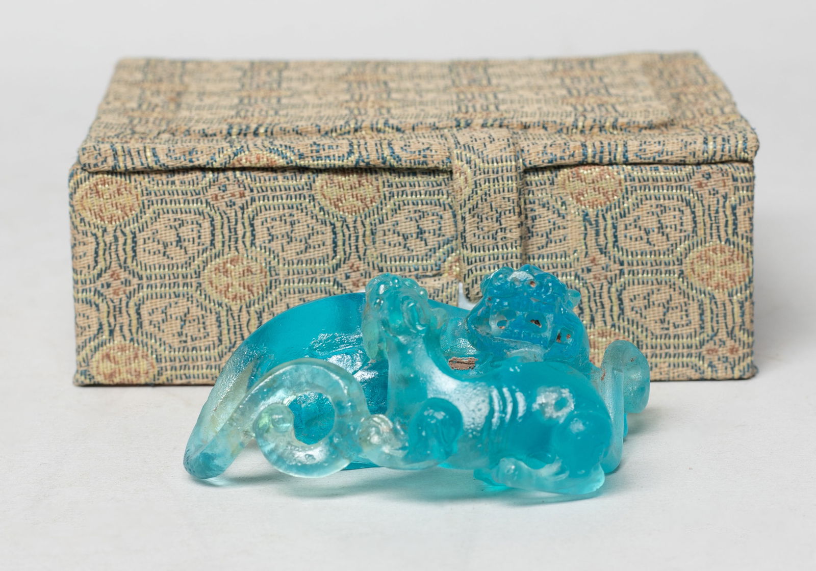 Estate Chinese Sapphire Blue Peiking Glass Beast: Carved as a single-horned beast turning back to gaze at its cub, the paws tucked underneath, the glass of sapphire blue color, with box. Approx. 2.5*2*1.1 inch (w/o box).
