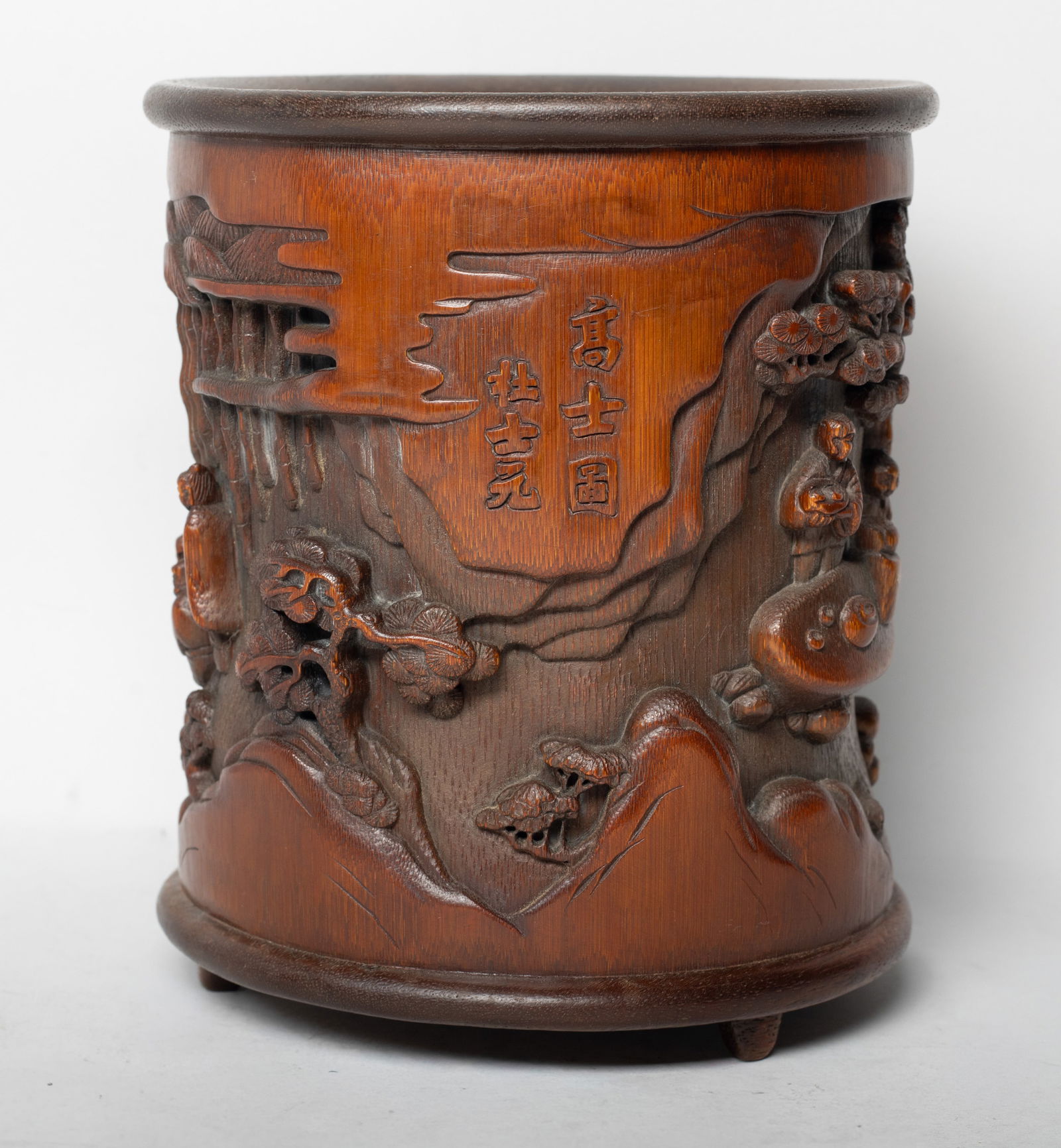 Vintage Chinese Bamboo Carved Brush Pot: The exterior carved in raised relief with a continuous scene of scholars in various activities amongst pine trees and bamboo, inscribed with related passages. Approx. 5.7*6.6 inch.
