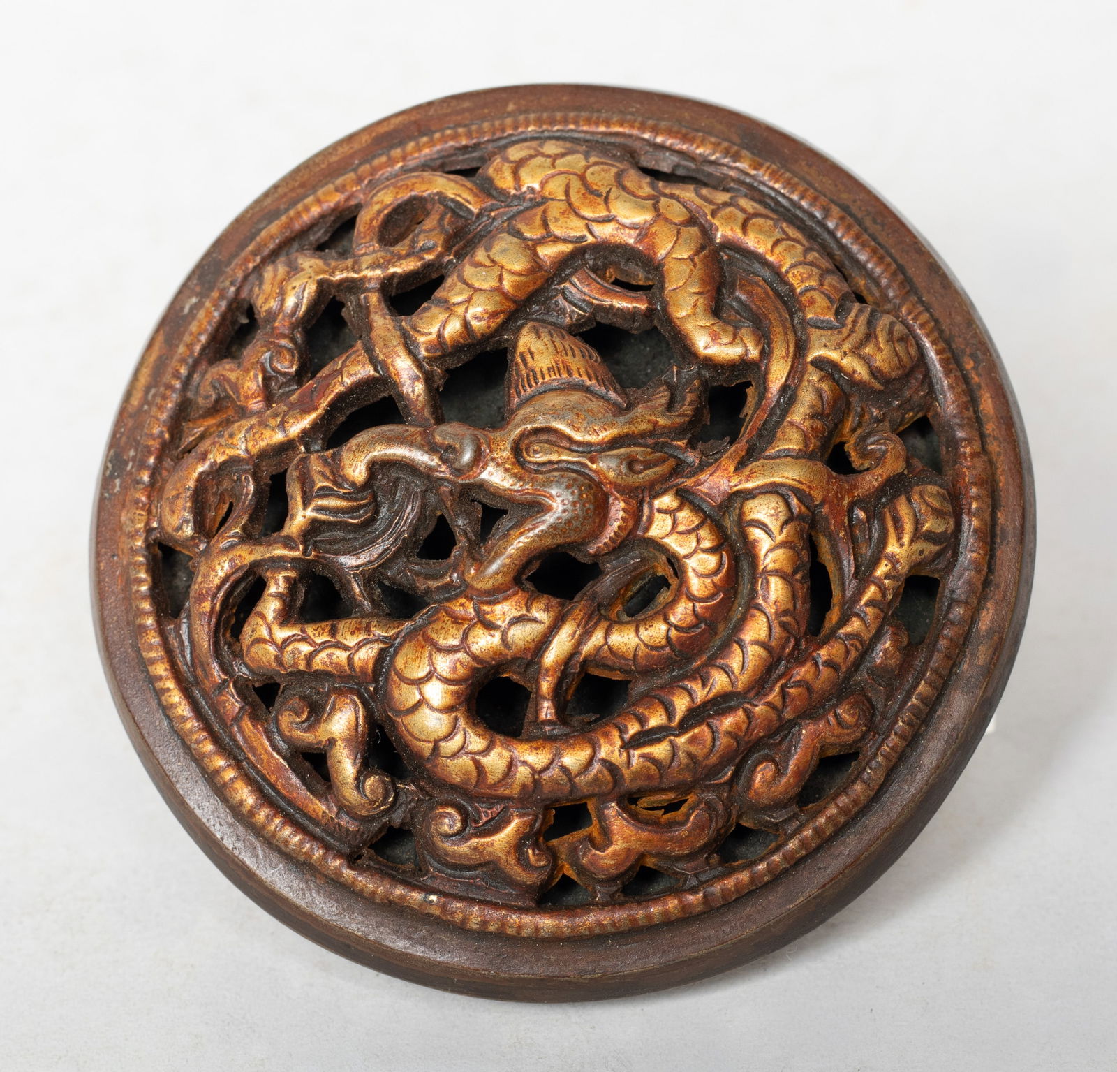 Rare Chinese / Tibetan Gilt Bronze Belt Buckle: Of circular shape, cast in openwork with a sinuous dragon intertwined with scrolls. Approx. 3.1 inch D.