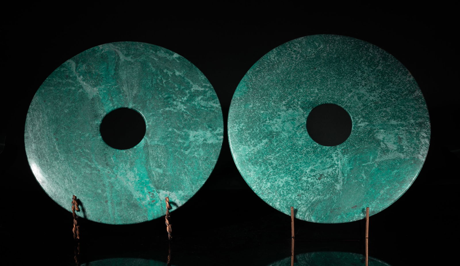 Two Mid Century Stone Disc Bi Sculptures: Two large stone carved disc bi sculptures, each of circular shape pierced with an aperture at the centre, with stands. Approx. 11.8 inch D (each w/o stand).