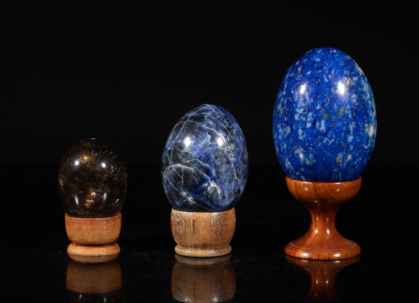 Set Lapis, Crystal Sculptures of Eggs: Set of three egg sculptures with stands, two carved of lapis, the other of crystal, each surface finely smoothed and polished. Approx. 2.9*2 inch (largest egg size).