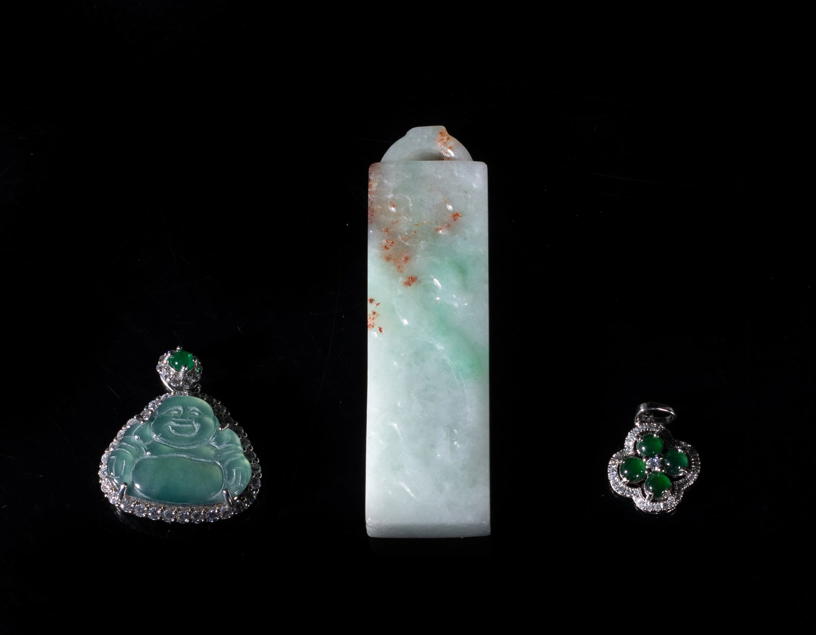 Three Vintage Chinese Export Jade Pendants: Set of three Chinese jade pendants, one of flower form, one carved with laughing Buddha, the other carved on one side with a taotie mask and a beast, the reverse side with a taotie mask above cloud
