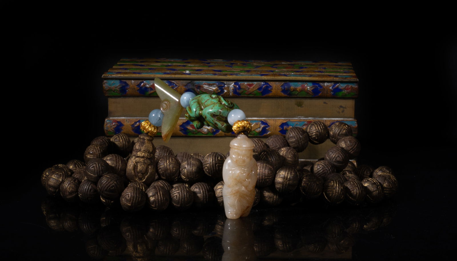 Chinese Gilt Mixed Agarwood Hexiang Prayer Beads: A long string of Chinese gilt mixed agarwood hexiang prayer beads, slightly fragrant, suspended with three stone beads, a russet jade toggle, a stone carved monkey form pendant, and a russet jade