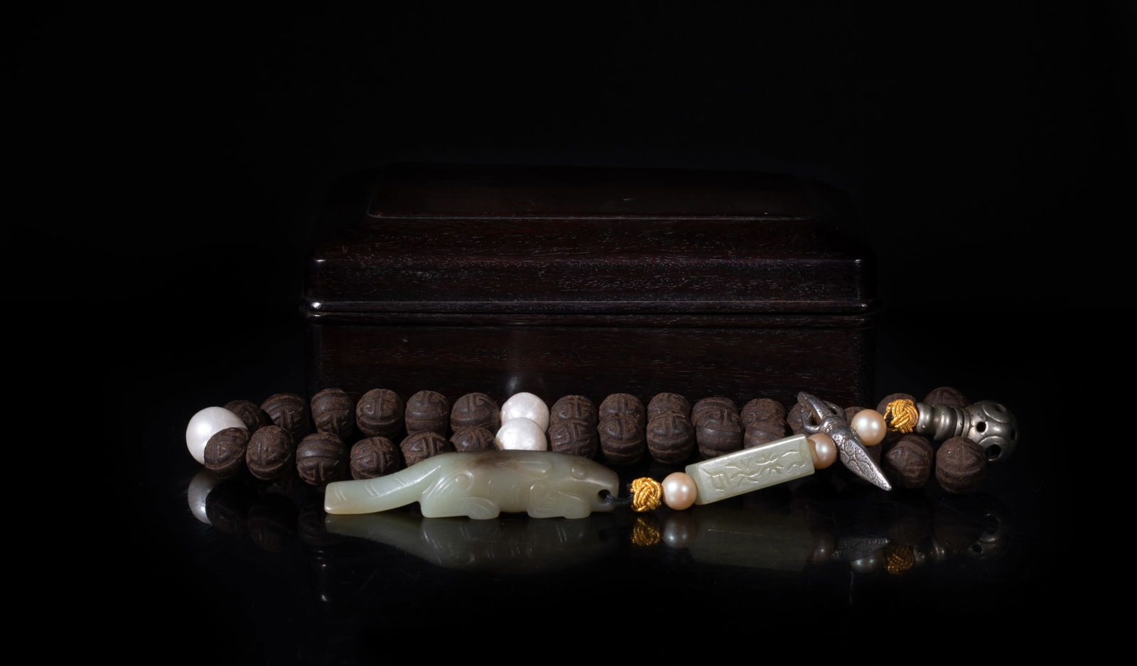 Chinese Mixed Agarwood Hexiang Prayer Beads: A string of Chinese mixed agarwood hexiang prayer beads and three pearl, slightly fragrant, suspended with metal toggles, beads, a jade bead, a russet jade toggle carved of recumbent beast form,