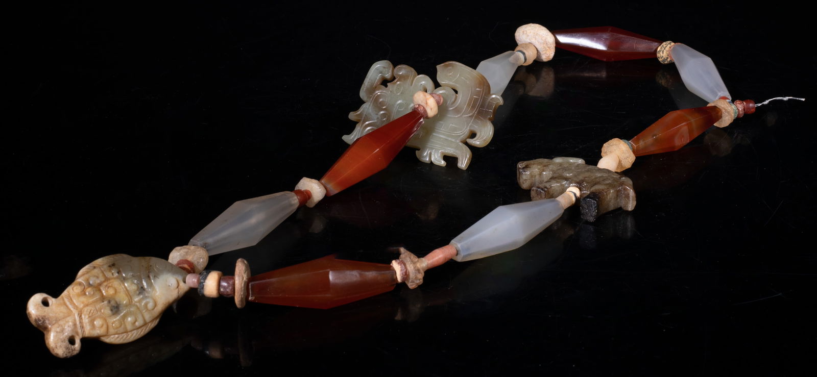 Chinese Jade & Agate Necklace: Chinese stone bead and long agate bead necklace, suspended with three russet jade toggles, carved fish or archaistic beast form. Approx. 24 inch L.