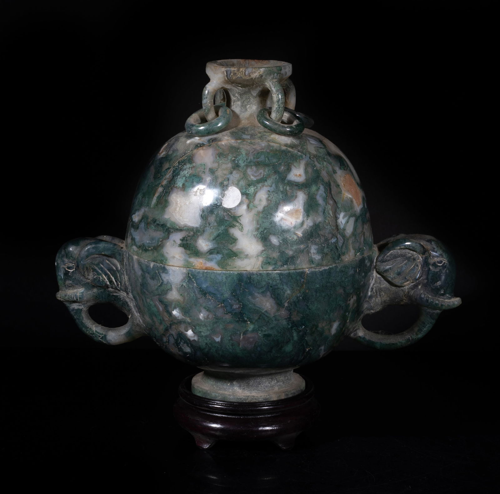 Early 1900s Chinese Large Moss Agate Covered Bowl: The globular body rising from a splayed foot to a short neck set with four loops, flanked by a pair of elephant head handles, with a wood stand. Approx. 8*9.6*5.8 inch (w/o stand).