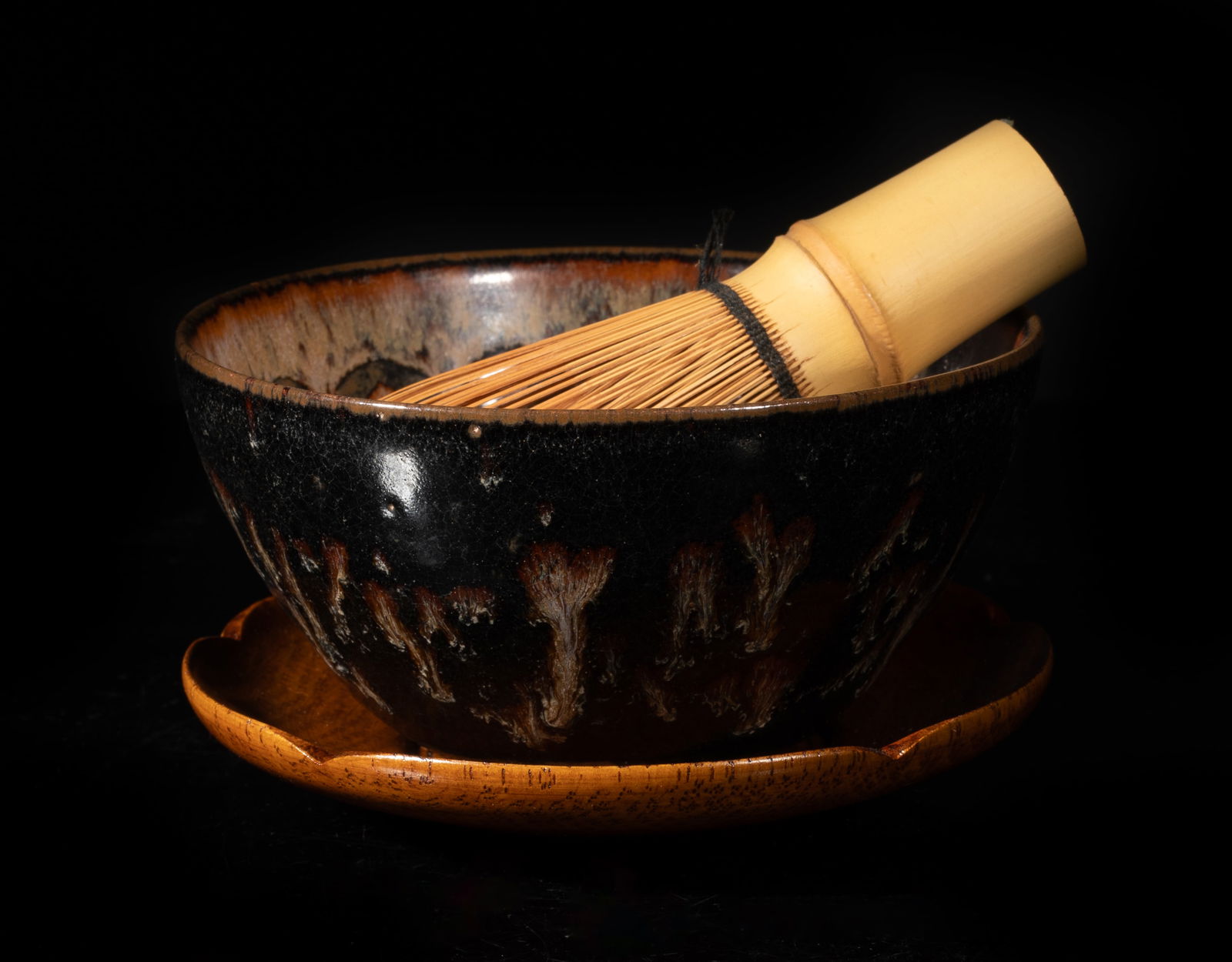 Chinese Export Jichou Porcelain Tea Bowl: The interior decorated with stylized paper-cut circles scattered neatly over a variegated glaze of mottled grey and light chestnut tones deepening to an amber toned rim, the exterior covered with a