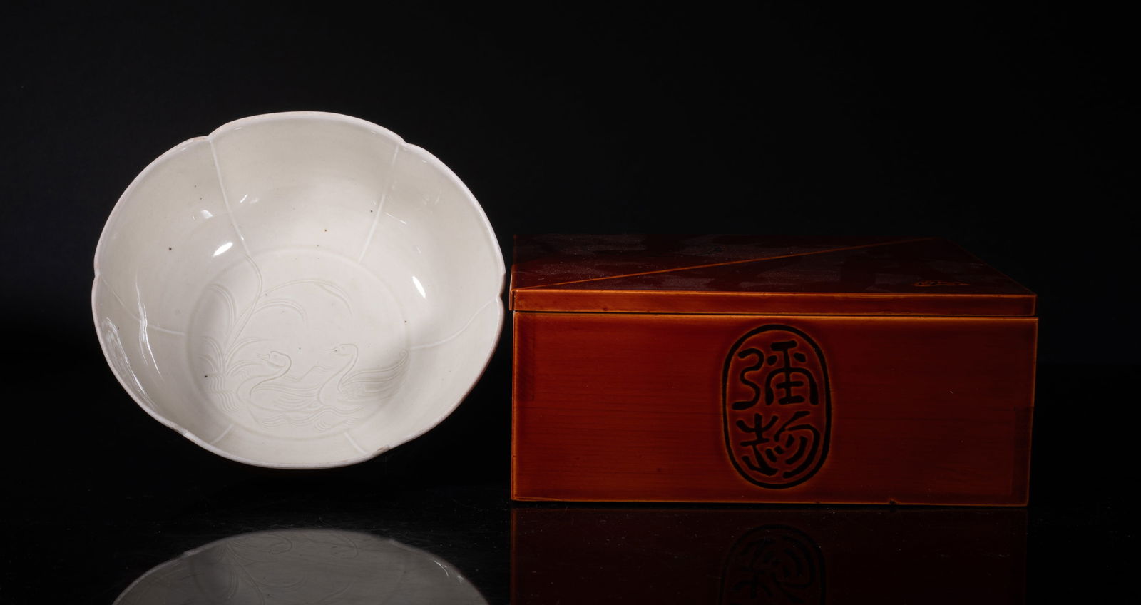 Rare Chinese DingWare Porcelain Brush Washer: Molded of floral form, the interior centre carved in low relief with a pair of ducks among reeds and waves, covered with creamy glaze, the exterior covered with rich brown glaze, with box. Approx.