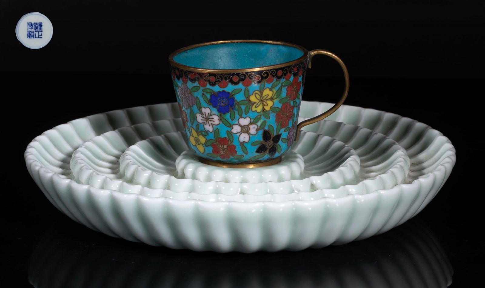 Rare Chinese Porcelain Base w/ Cloisonne Cup: The porcelain base carved with three layers of chrysanthemum petals, the interior centre incised with a stylized shou character, overall covered in soft celadon glaze, the bottom marked with four
