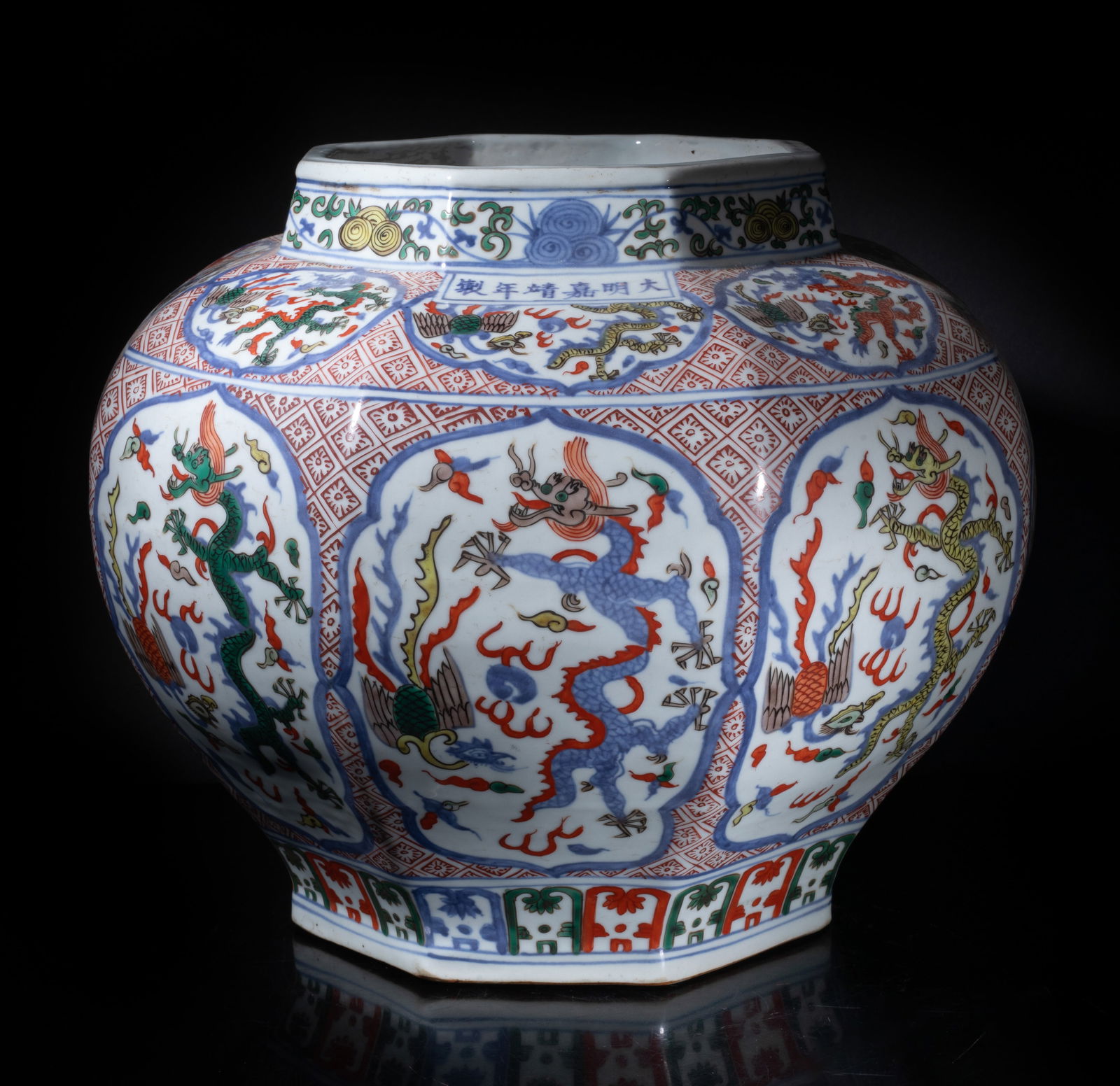 Massive Chinese Export Garden Used Porcelain Jar: The tapered ovoid body of octagonal section, each side painted with two ruyi-head shaped medallions of dragon and phoenix chasing a flaming pearl amidst clouds, ground with copper red checked patterns