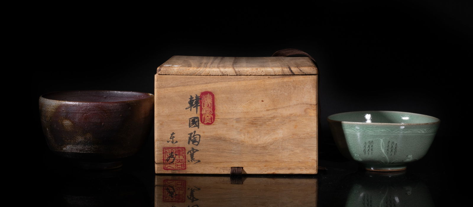 Two Korean Porcelain Tea Bowls: One bowl covered with crackled celadon glaze, the exterior painted with ducks and willow trees, the other bowl covered with mottled brown glaze, with box. Approx. 5*3.1 inch (larger).