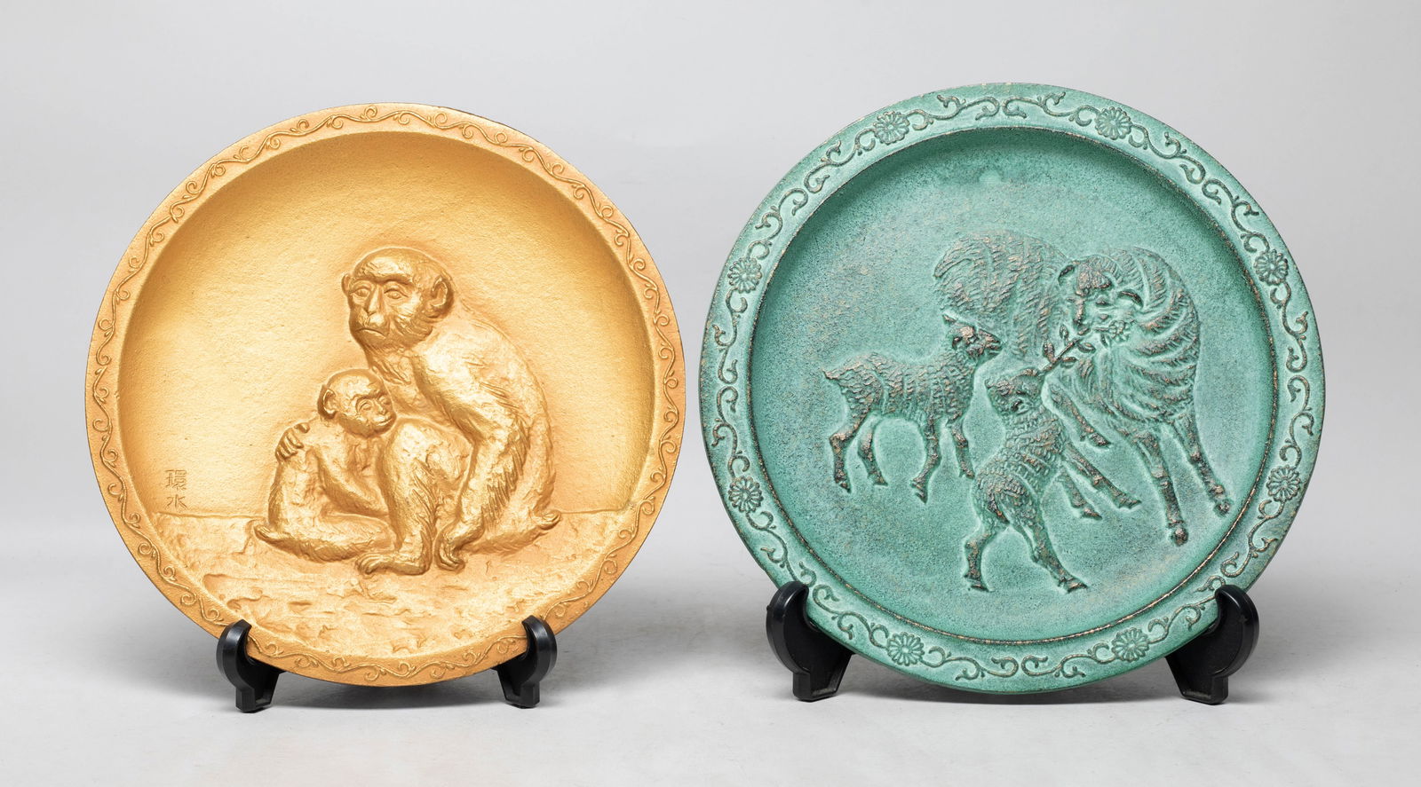 Two Japanese Limited Edition Metal Plates: One cast with a monkey cuddling its cub, the other cast with a sheep and two lamb, each with a stand. Approx. 9.8 inch D (larger).