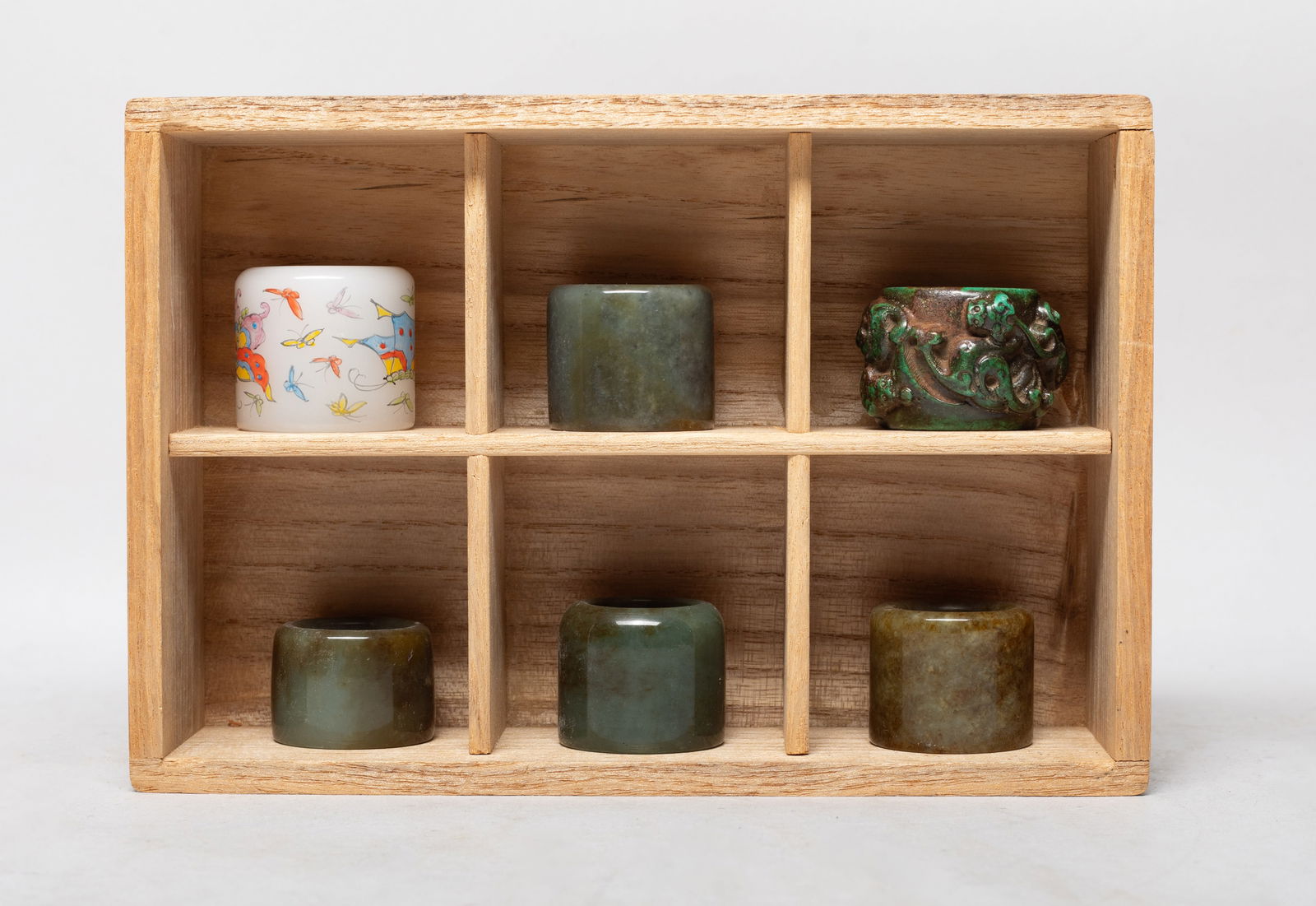 Estate Set Chinese Jade, Stone, Glass Thumb Rings: Set of six Chinese thumb rings, carved of russet jade, stone or glass, the stone ring carved in high relief with chi dragons, the glass ring painted with butterflies and marked with four characters,