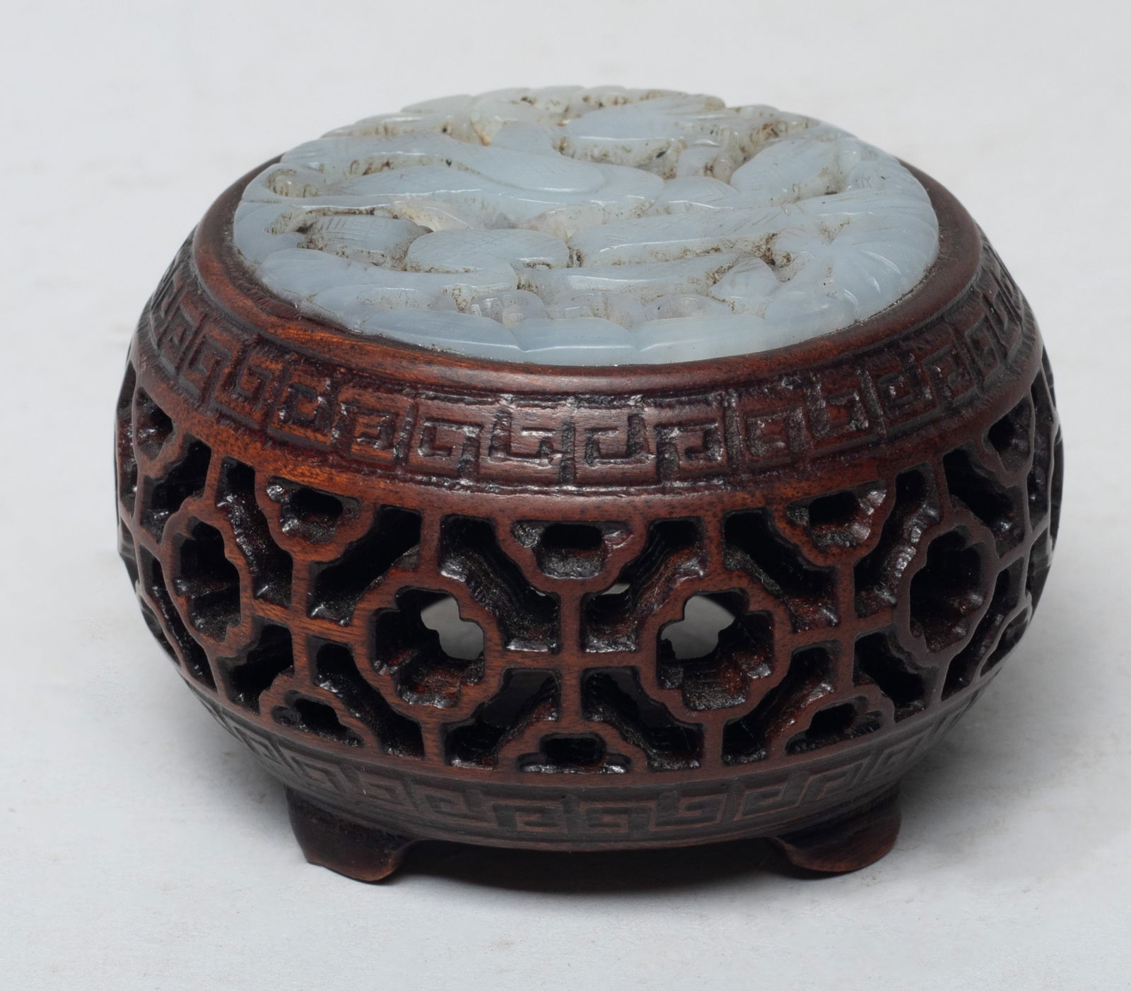 Chinese Carved Wood Piece Inlaid Jade: Of rounded form, the sides carved in openwork with traditional motif, the top inlaid with a gray glaze plaque, carved and reticulated with a dragon among foliage. Approx. 2.65*1.67 inch.