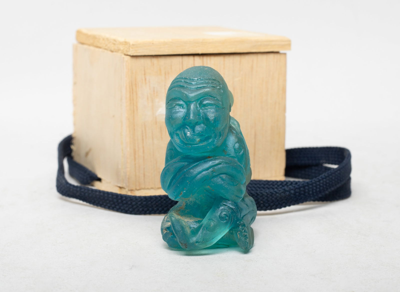 Rare Chinese Peiking Glass Sculpture: Carved as stylized seated figure form, the arms and legs crossing, with covered box. Approx. 2.6*1.7*1.2 inch (w/o box).