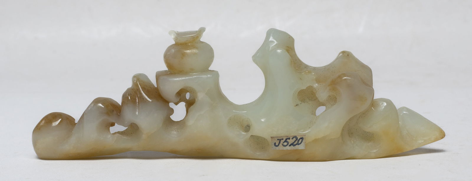 Chinese Russet Jade Brush Stand: The russet jade brush stand carved and reticulated of craggy rockwork form, with a jar on the rock, minor chips. Approx. 5.1*1.6*0.6 inch.