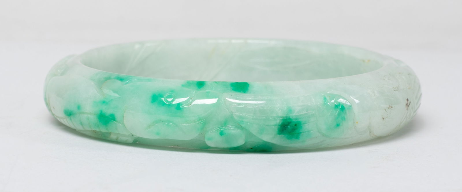 Vintage Chinese Export Colored Stone Bangle: Chinese colored stone carved bangle, carved in raised relief with a dragon confronting with a phoenix. Approx. 3.13 inch outer diameter, 2.48 inch inner diameter.