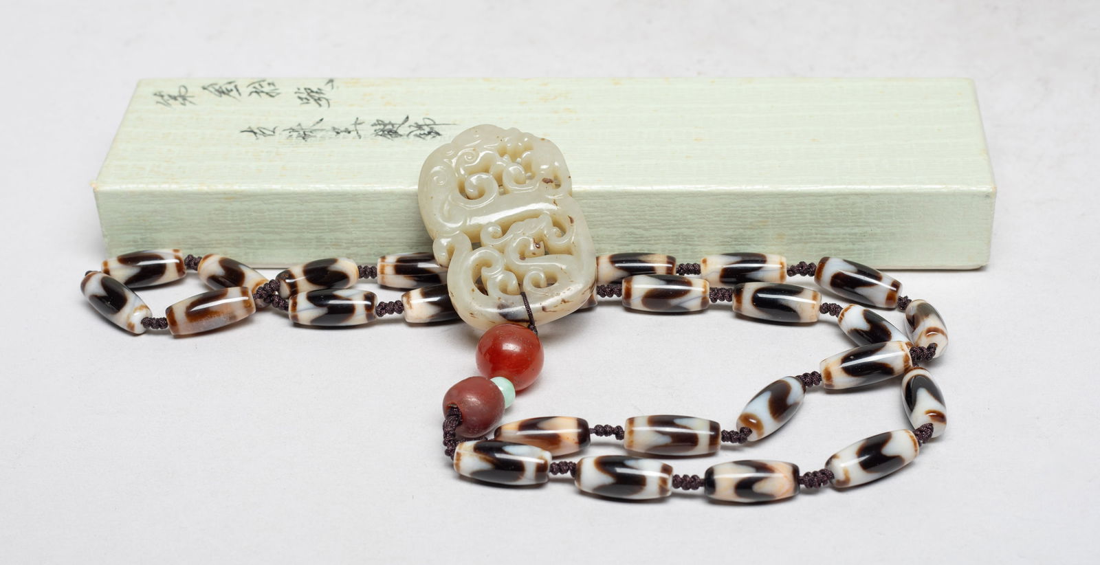 Estate Chinese Export Dzi Beads Necklace w/ Jade: Chinese dzi bead necklace, suspended with three gemstone beads and a jade toggle carved in openwork with stylized dragons and beasts, with box. Approx. 2*1.3 inch (jade size).