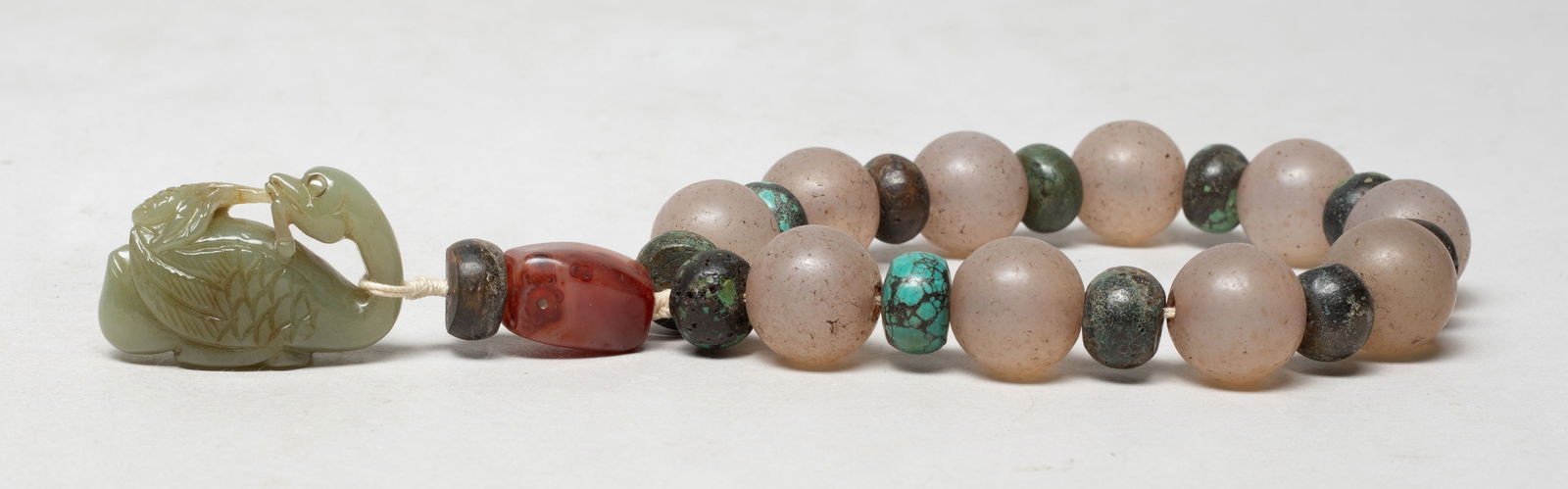 Estate Chinese Jade, Agate, Stone Prayer Beads: A string of Chinese stone carved prayer beads, suspended with an agate bead, a stone bead, and a jade toggle carved as a duck looking back and grasping ear of rice in the mouth. Approx. 1.6*1.2*0.6 in