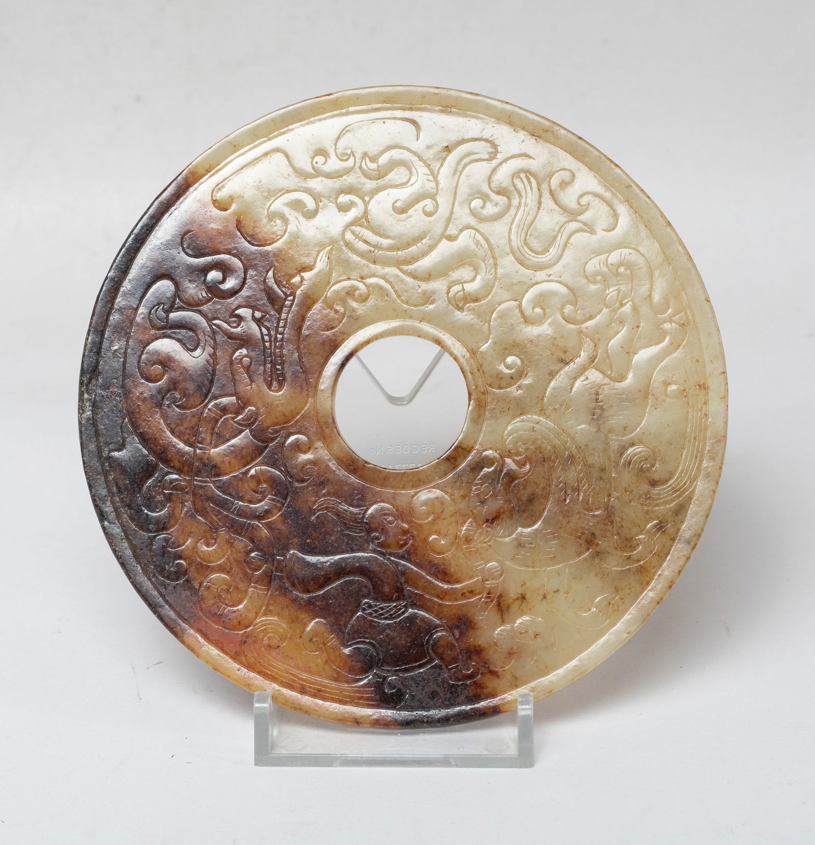 Large Chinese Russet Jade Bi: Of circular shape pierced with an aperture at the centre, either side carved with a figure battling with mysterious beasts. Approx. 4.7 inch D.