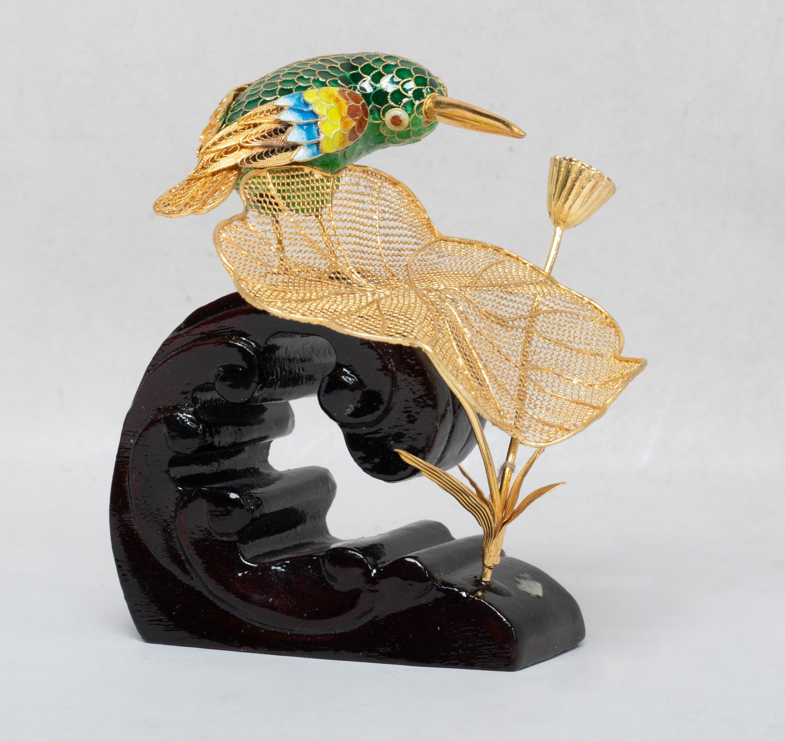 Chinese Gold on Sterling Silver Sculpture: Molded as a bird around a reticulated lotus leaf and a lotus seedpod, the bird applied with dark-green, yellow-green, blue and brown glaze, with a wave form base. Approx. 3.5*3.5*3.9 inch.