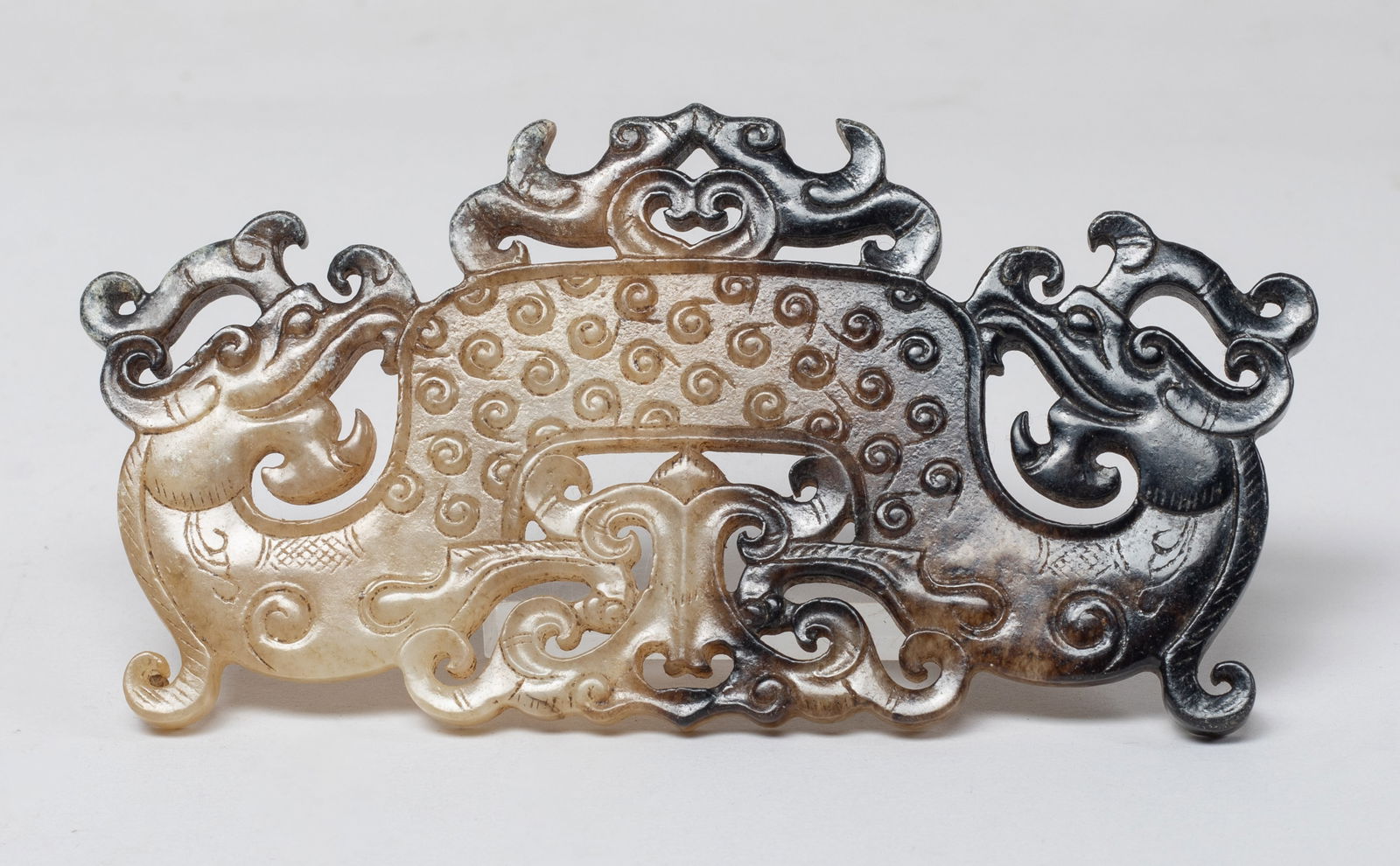 Estate Chinese Russet Jade Dragon Pendant: Worked as an archaistic dragon with twin heads, both sides detailed with raised spirals, below and above with pair of stylized beasts. Approx. 5*2.57 inch.