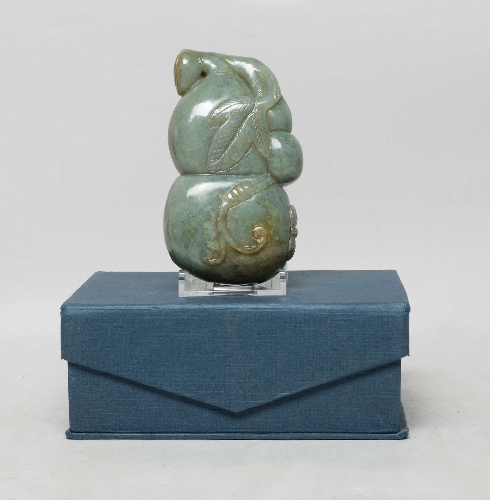 Large Chinese Russet Jade Gourd Sculpture: Of natural gourd form carved with a long stem, with smaller gourds and leaves, that trail from the side of the upper gourd neck and that wraps around the sides to the large lower gourd section, with