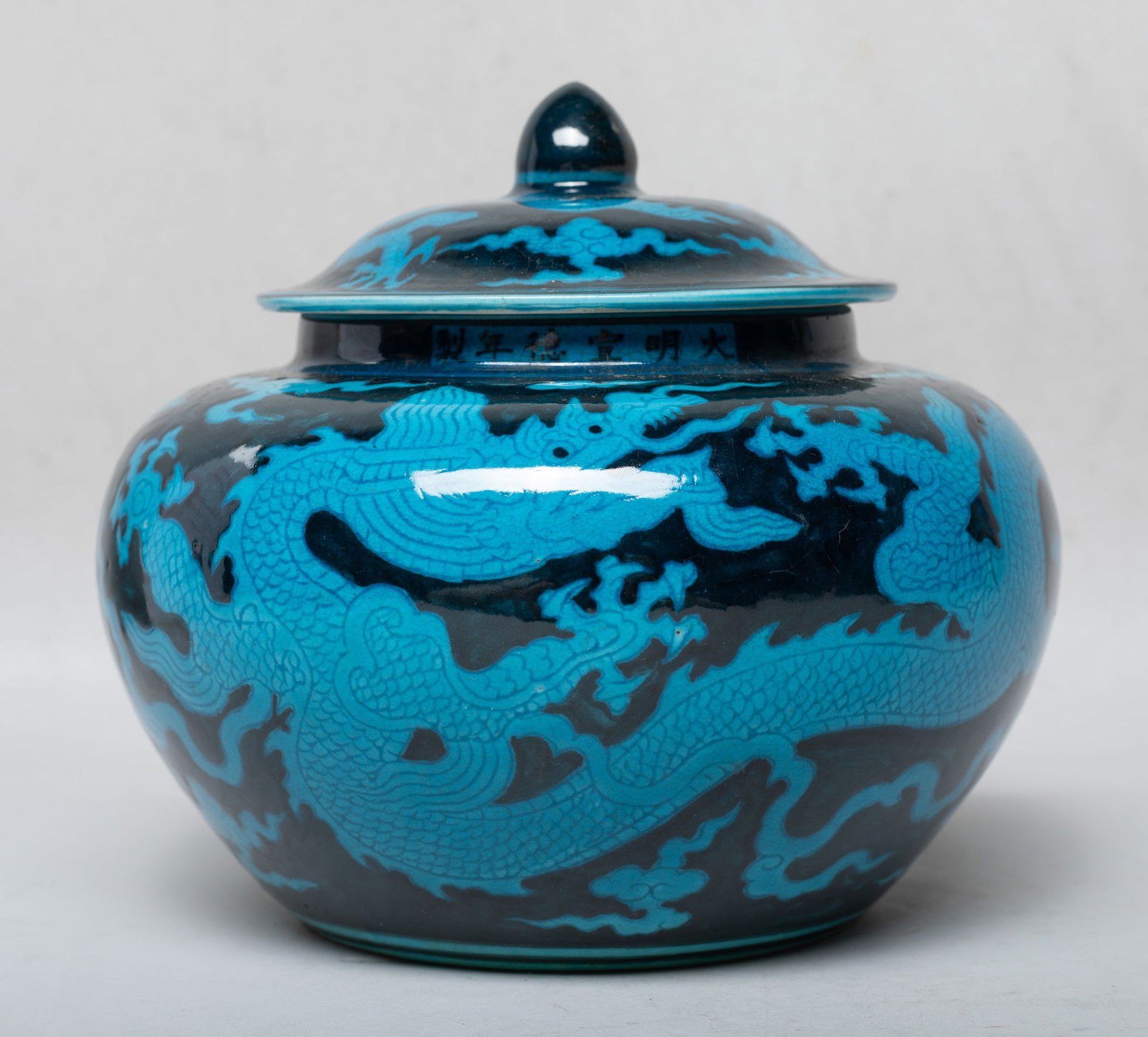 Estate Chinese Export Porcelain Covered Jar: The jar body and lid exterior decorated with five-clawed dragons sinuous amidst clouds, glazed in blue color against crackled bluish black glazed background, the rim marked with six characters. Approx