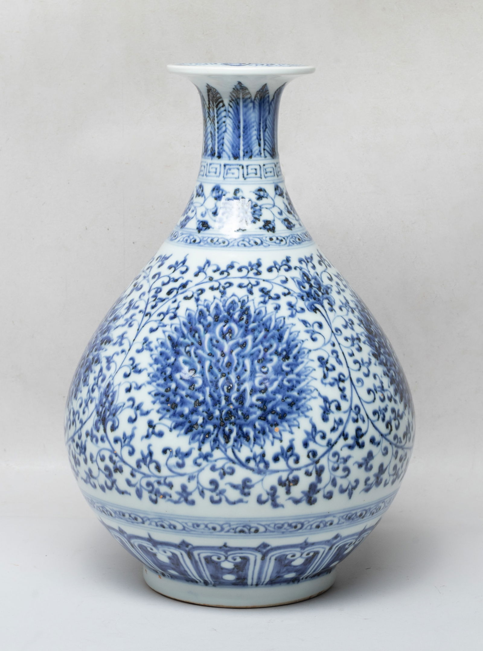 Large Chinese Export Porcelain Vase: Of pear shape rising from a short foot to a waisted neck and a flared rim, the exterior decorated with undulating lotus foliage, under bands of leaves and floral sprays, above a band of lappets, the