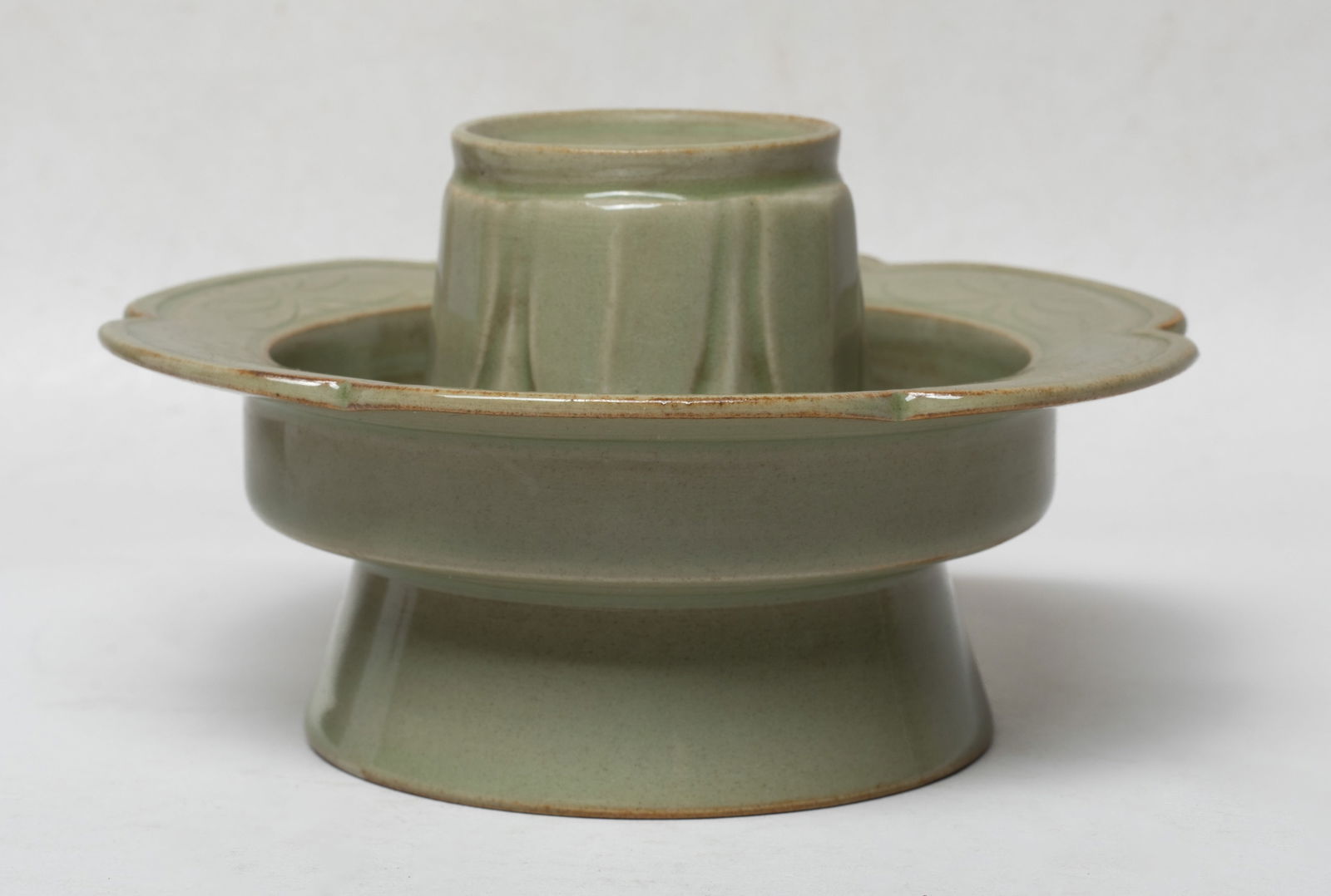 Chinese Yaozhou Ware Porcelain Stand: Molded of floral form incised with flowers on the rim, the central stand carved with overlapping leaves, the bottom drilled with an aperture, overall covered with celadon glaze. Approx. 5.2*3 inch.