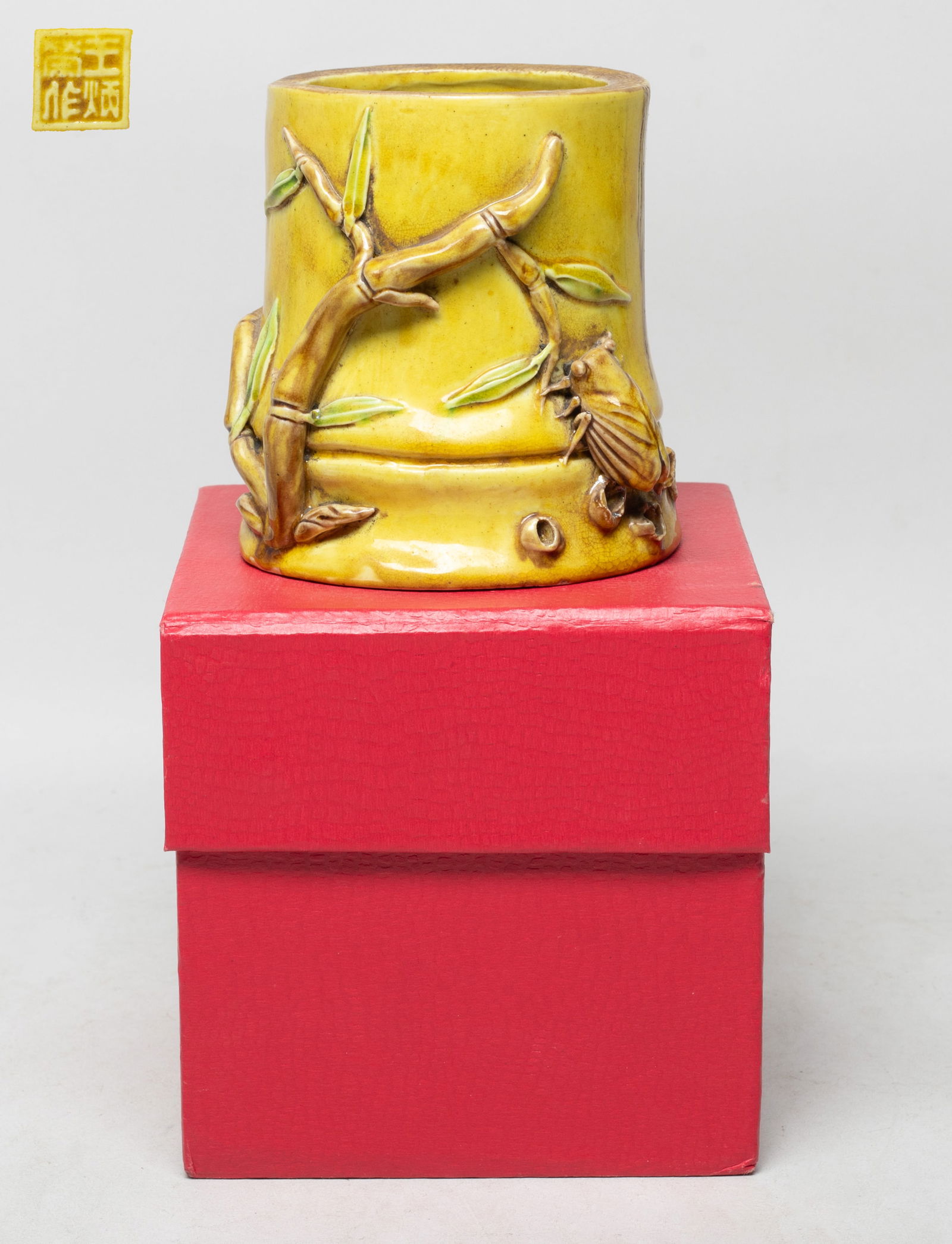 Estate Chinese Glazed Porcelain Brush Pot: Molded of bamboo form, carved in high relief with bamboo and cicada, the bottom with seal mark, overall covered with crackled yellow glaze, with box. Approx. 4.3*4.2*4.1 inch.